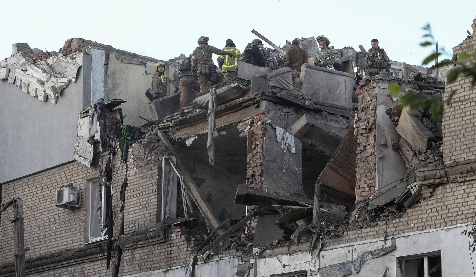 Firefighters work at a site of an apartment building destroyed during a Russian drone and missile strike in Dnipro