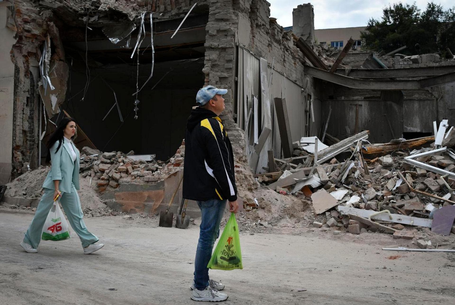 People pass by heavily damaged buildings after latest Russian rocket attack in Dnipro