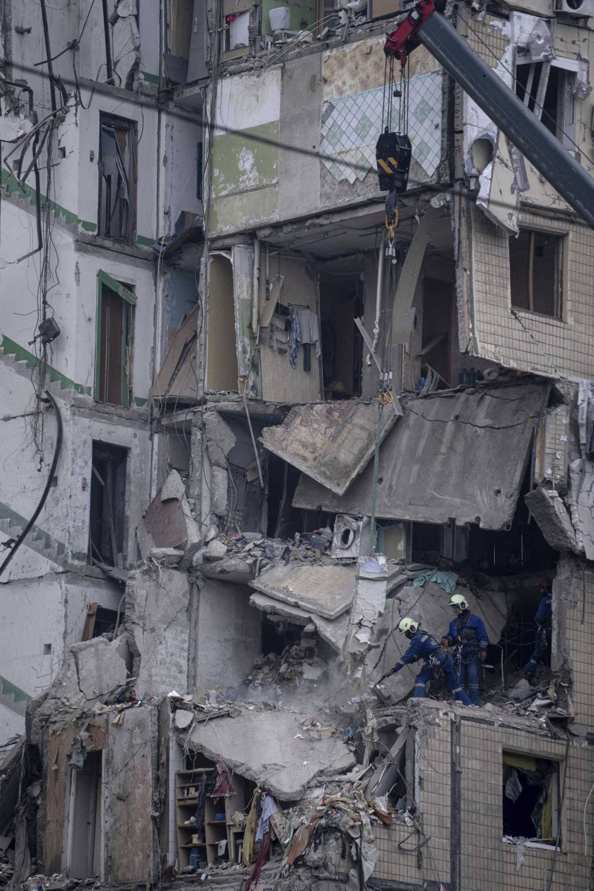 Rescue workers clear the rubble from an apartment building that was destroyed in a Russian rocket attack at a residential neighbourhood in the southeastern city of Dnipro