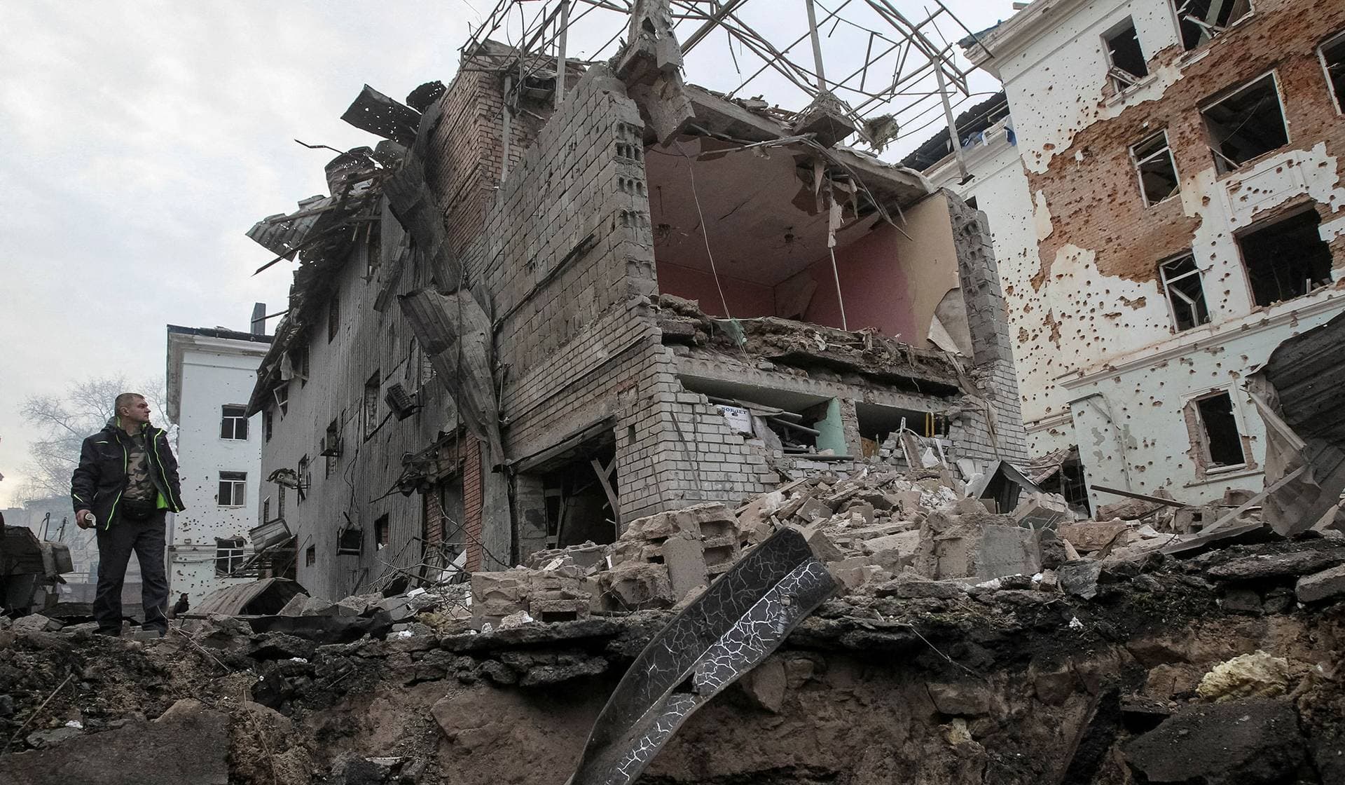 A resident stands near apartment buildings hit by a Russian missile and drone strike in Dnipro