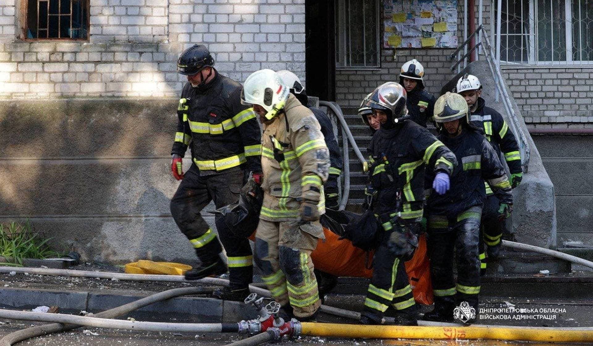Rescuers carry a body of the person found under debris of a building which was hit during Russian drone strike in Dnipro
