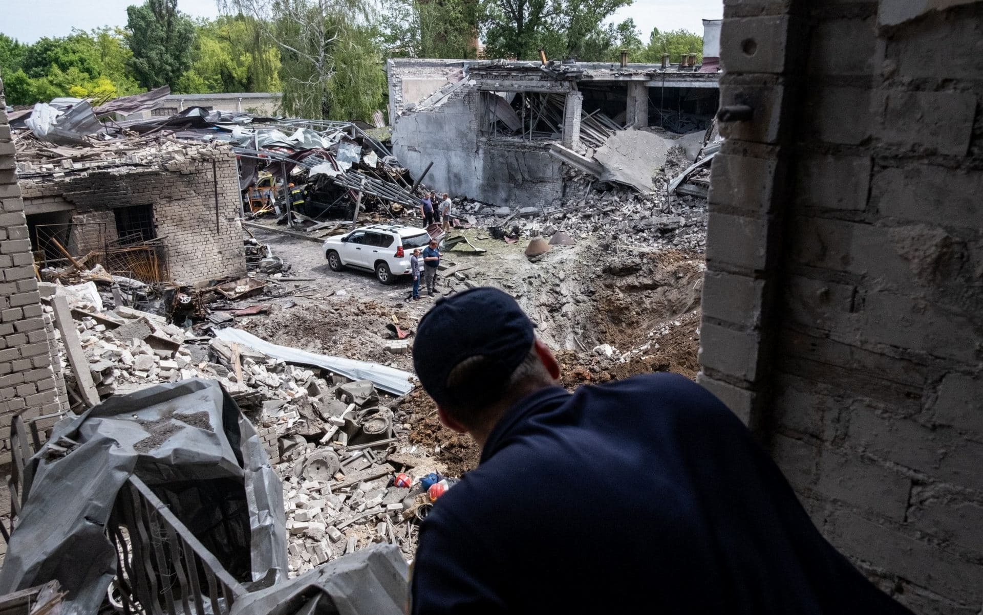 Ukrainian firefighter observes the damage left behind by a missile strike at a building that housed a fire station and a laboratory in Dnipro