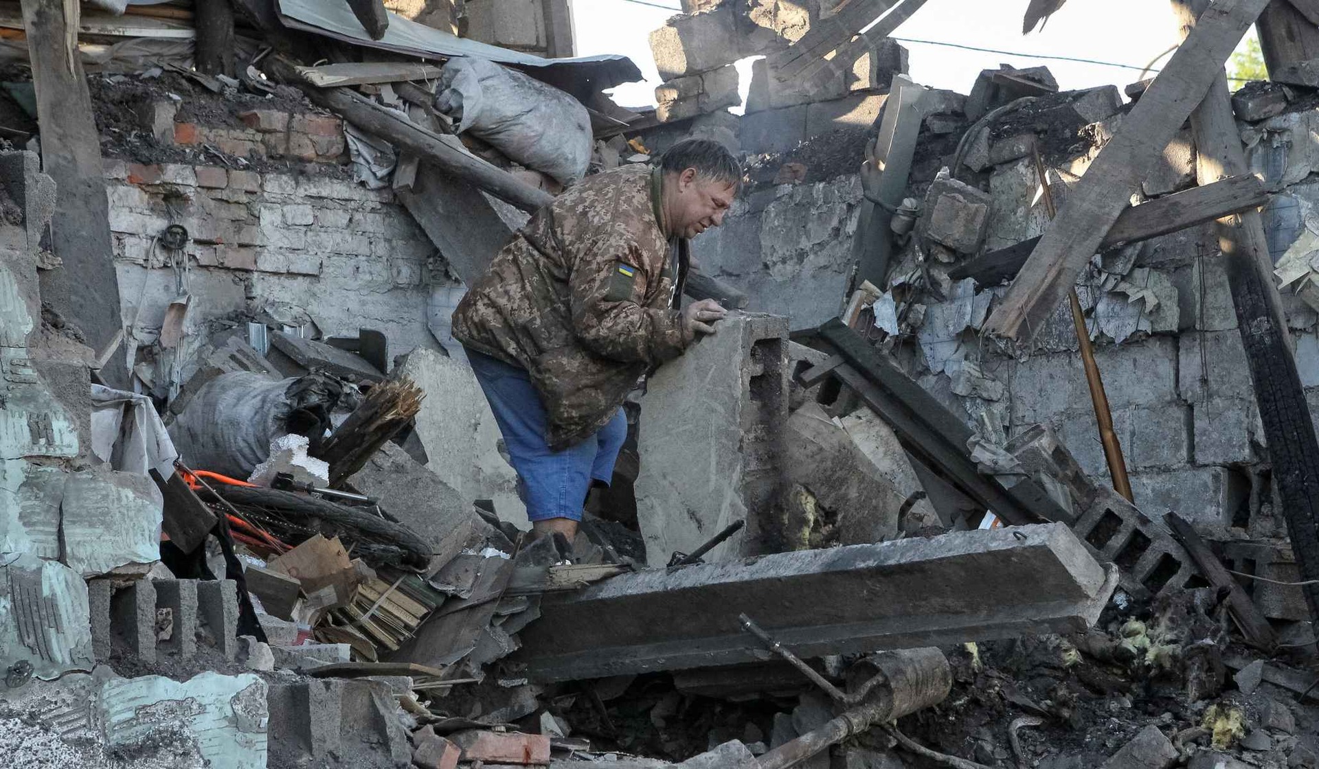 A resident inspects a house damaged by Russian drone strikes in Dnipro