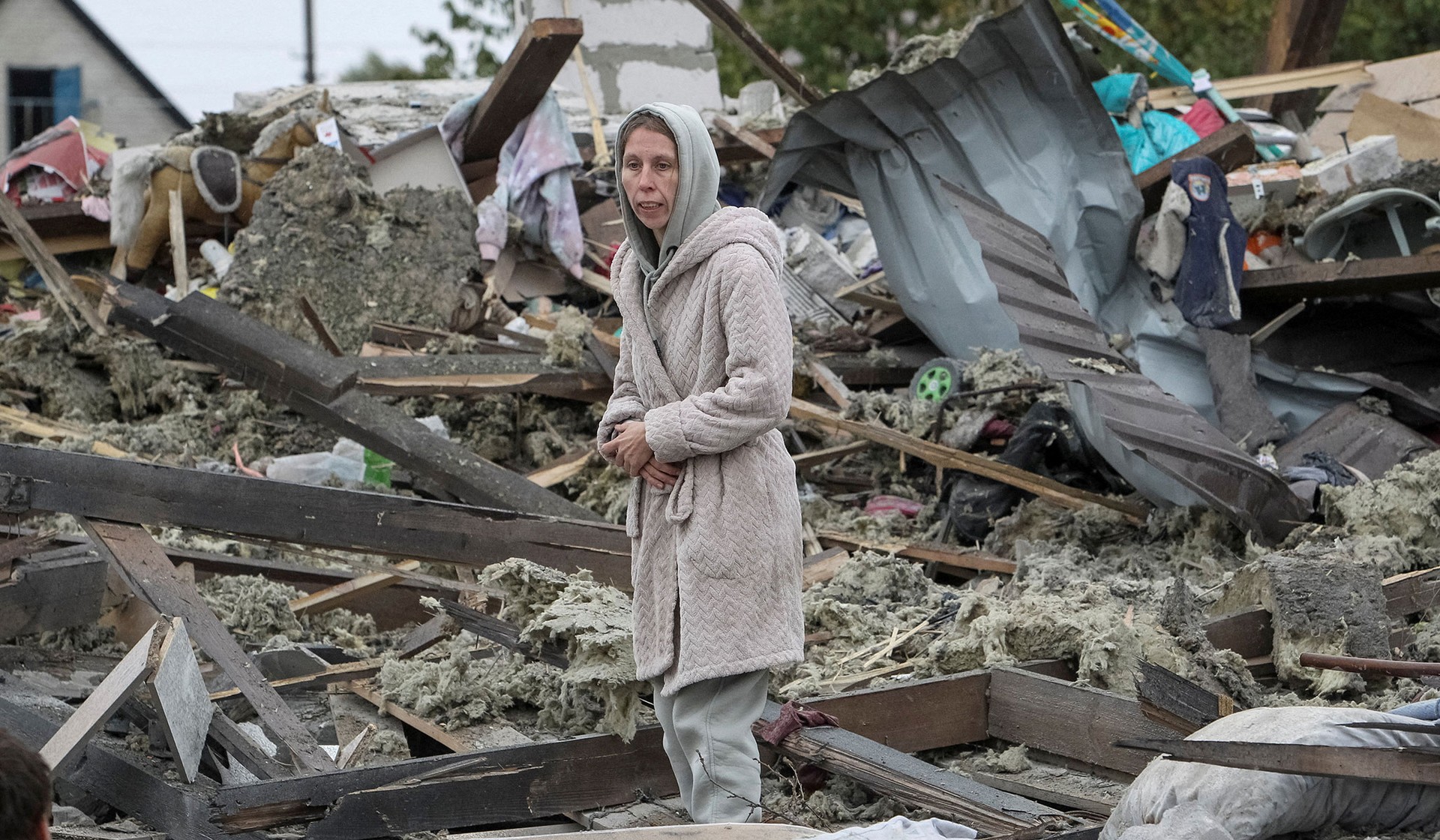 A woman stands at the site of her in-laws' private house, destroyed during a Russian air strike on the outskirts of Dnipro