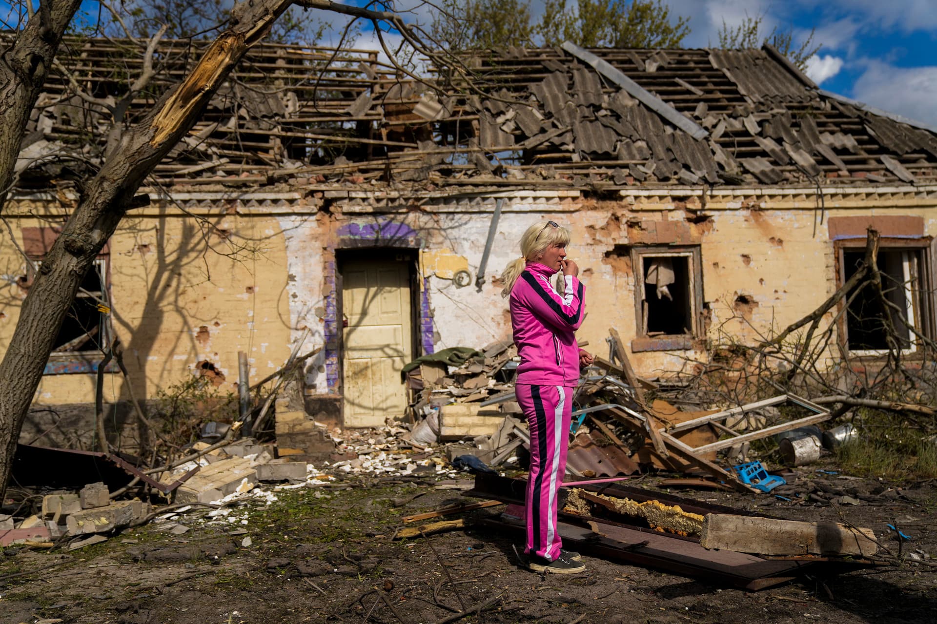 Iryna Martsyniuk stands next to her house, heavily damaged after a Russian bombing in Velyka Kostromka village