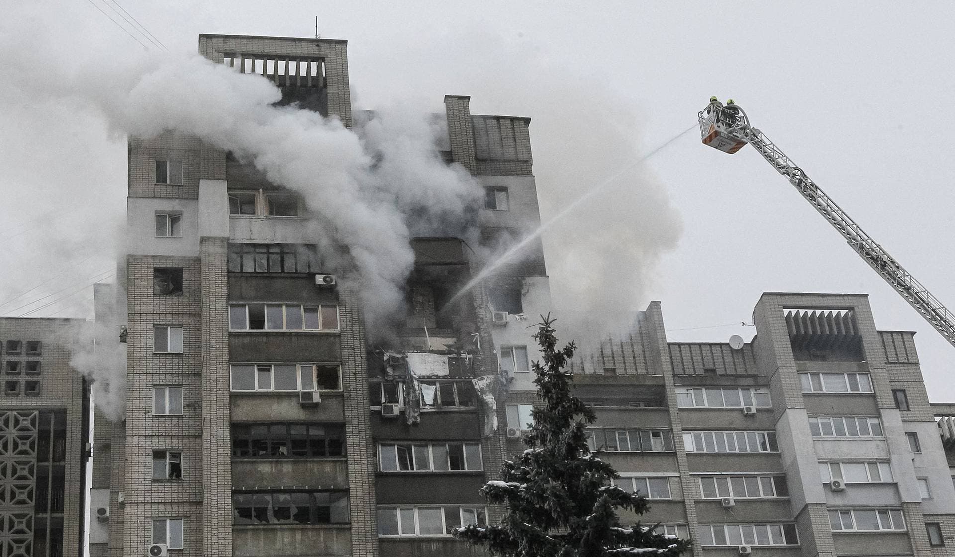 Firefighters work at the site of the apartment building hit by a Russian drone strike in Dnipro