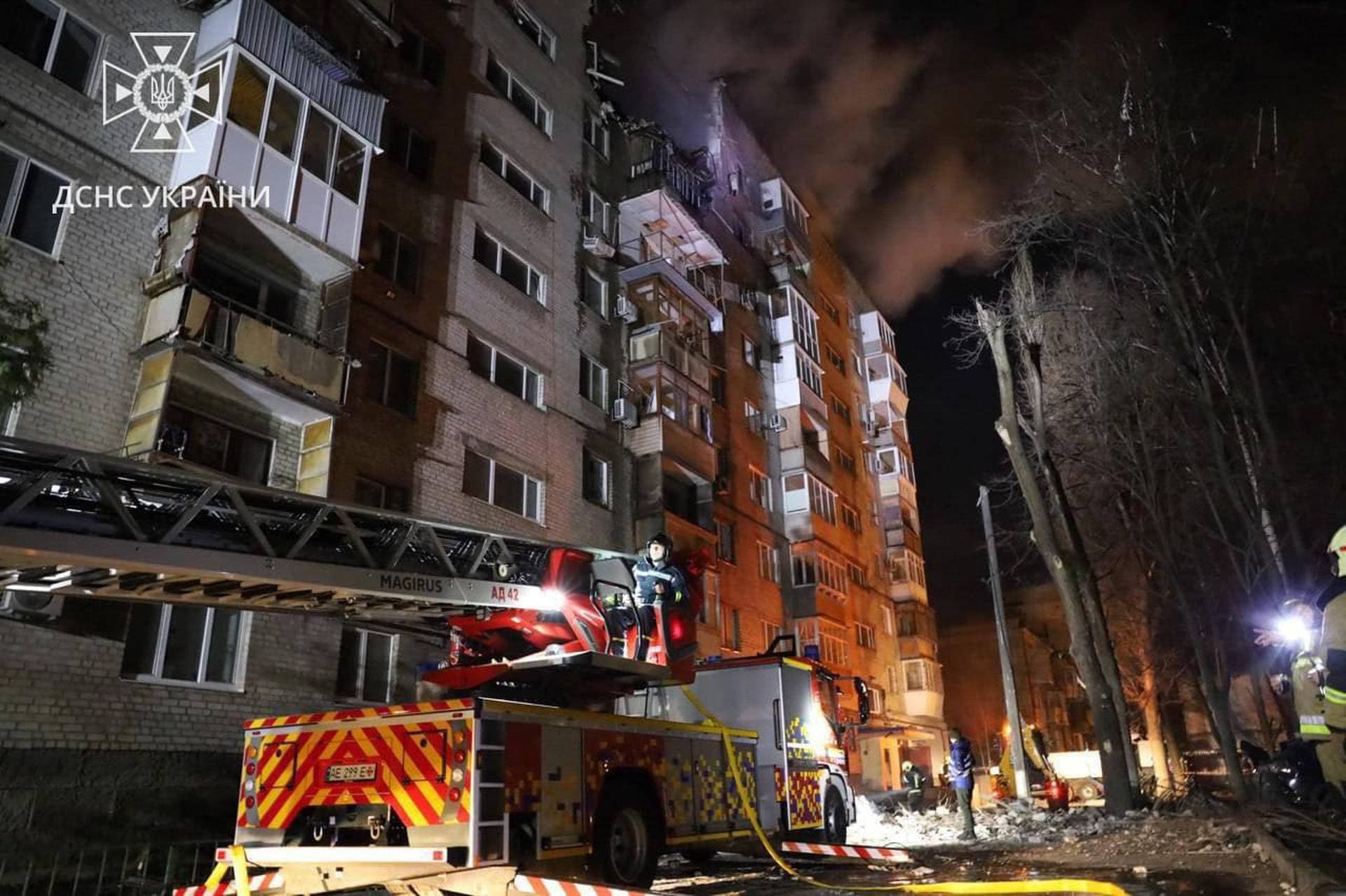 Firefighters work at a site of a residential building damaged by a Russian drone strike in Dnipro