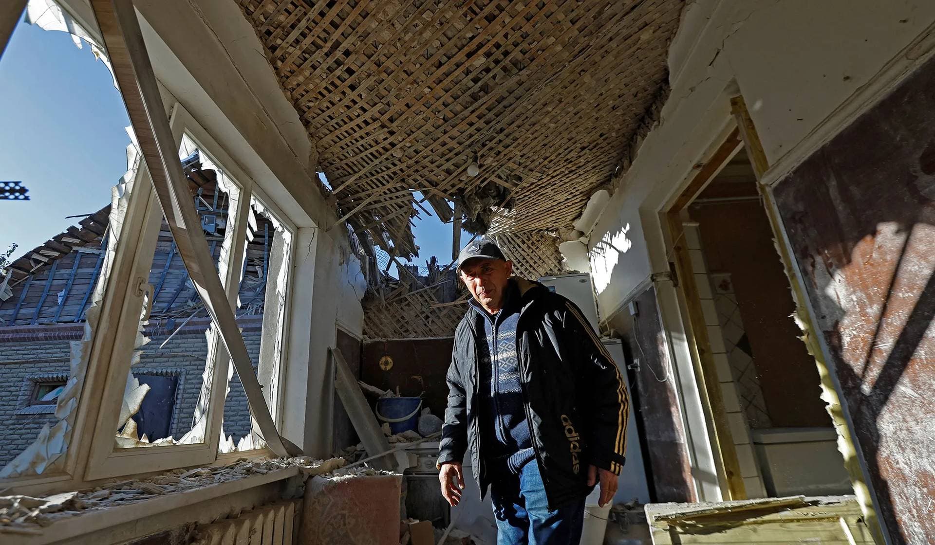 Local resident walks inside his house damaged by recent shelling in Donetsk