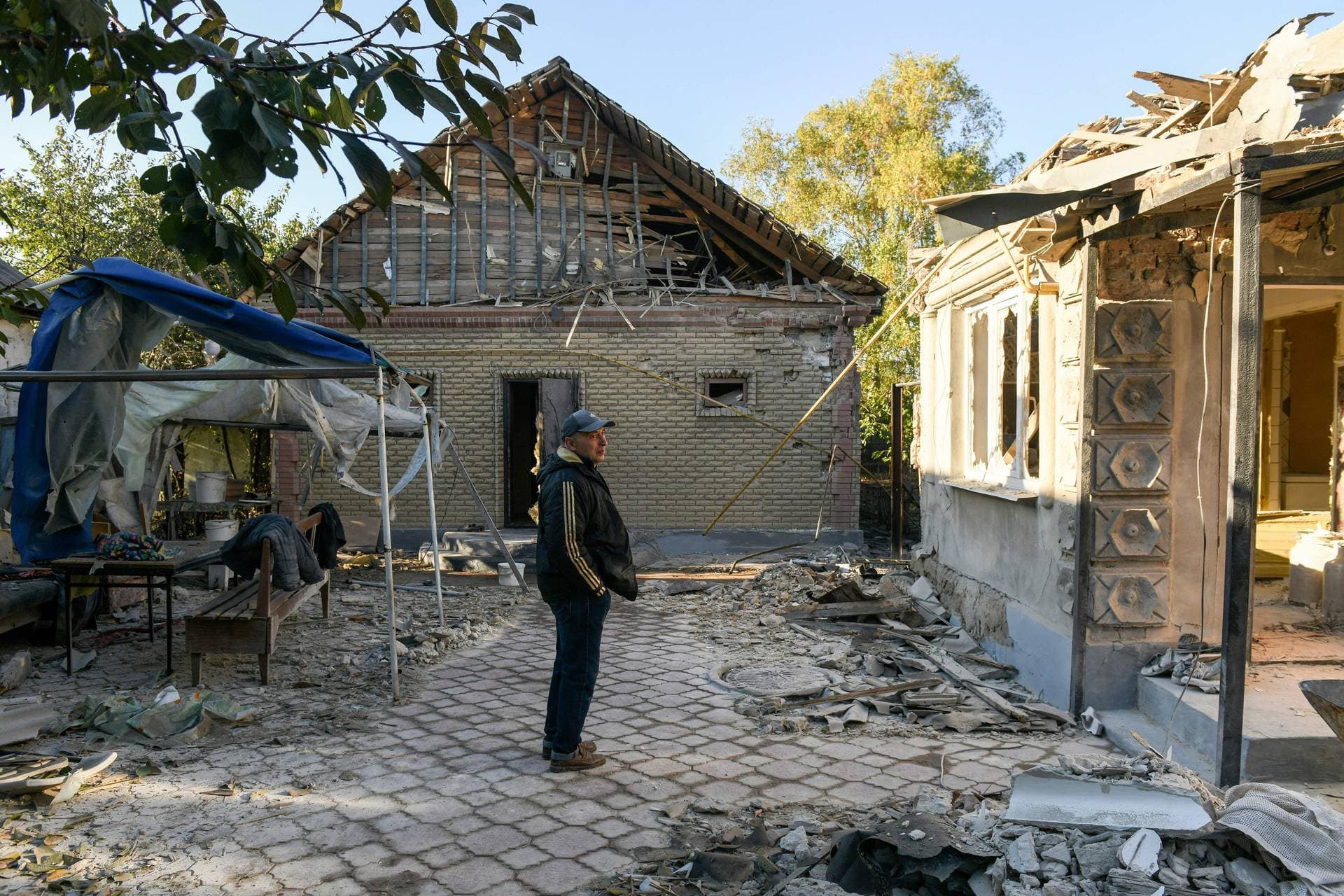 A man stands in the courtyard of his house damaged due to a missile strike in Donetsk