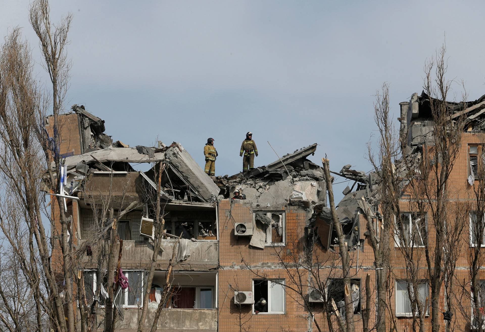 Firefighters work at a residential building damaged by shelling during Ukraine-Russia conflict in the separatist-controlled city of Donetsk
