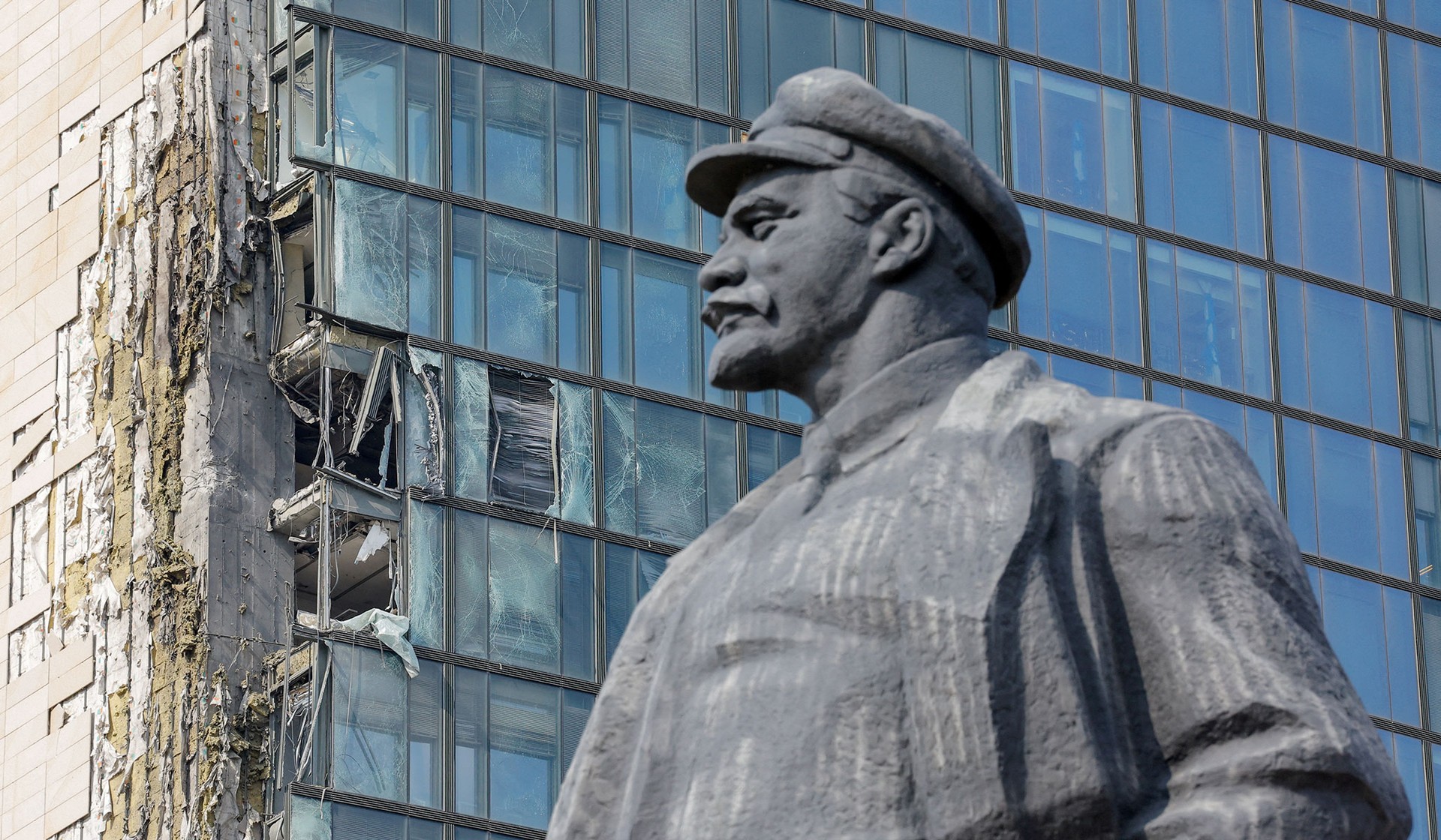 A monument of Vladimir Lenin stands in front of a damaged business center in Donetsk