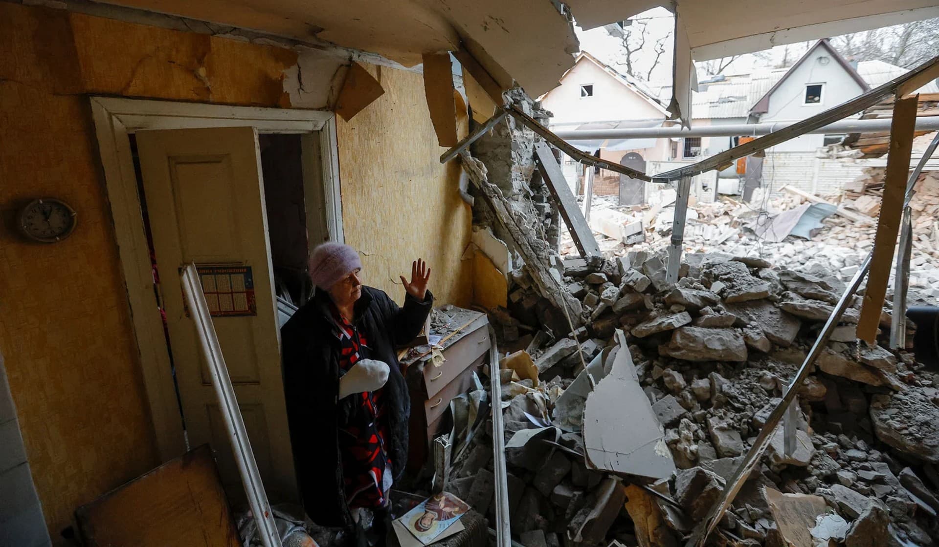 Local resident Svetlana Boiko, 66, who was injured in recent shelling, reacts outside her destroyed house in Donetsk