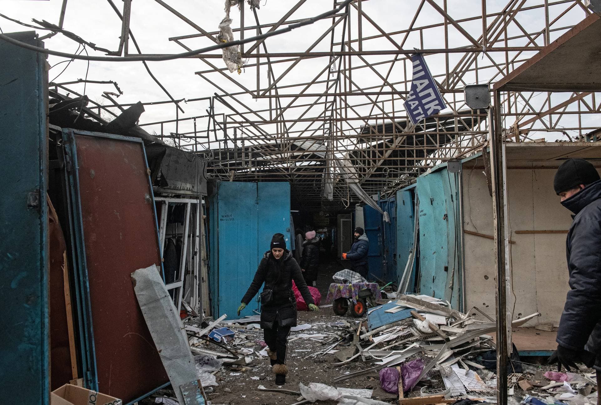 Vendors remove debris at a local market following recent shelling in Donetsk