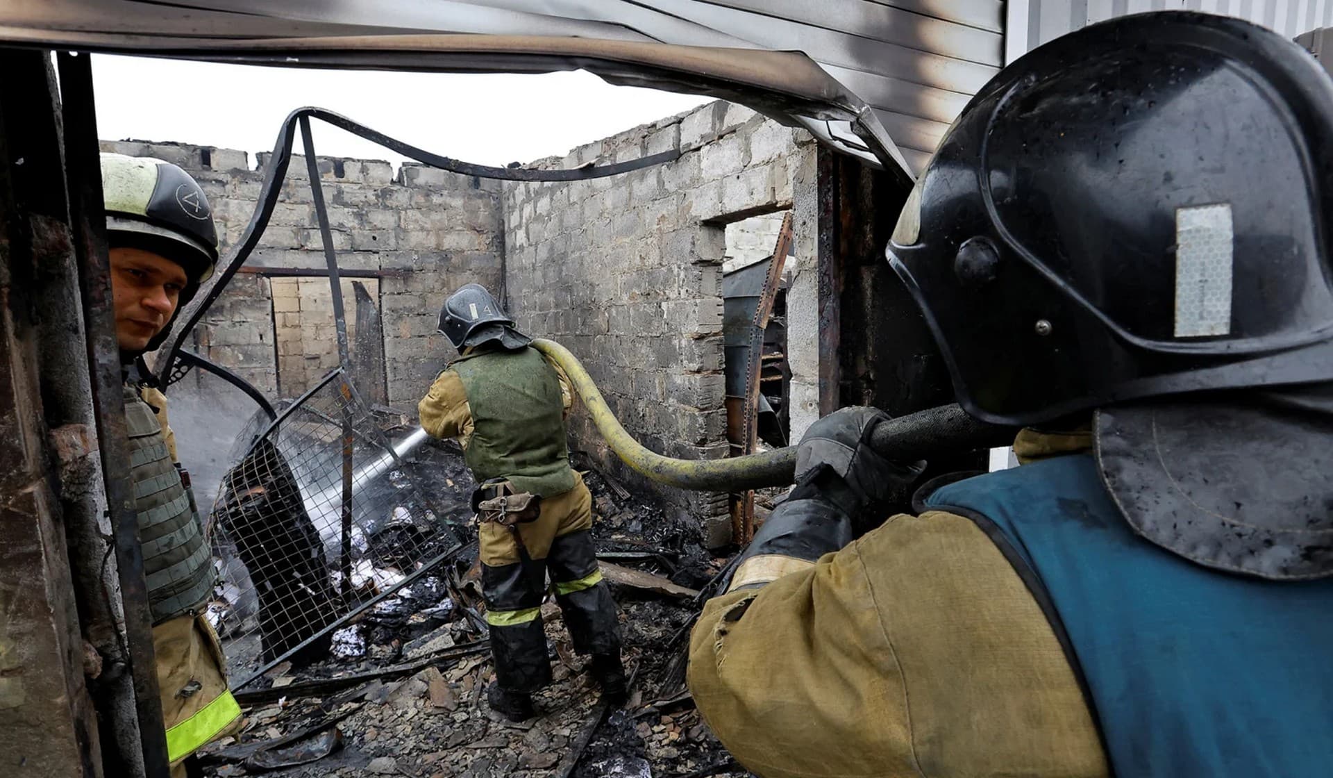 Firefighters work at a local market hit by shelling in Donetsk