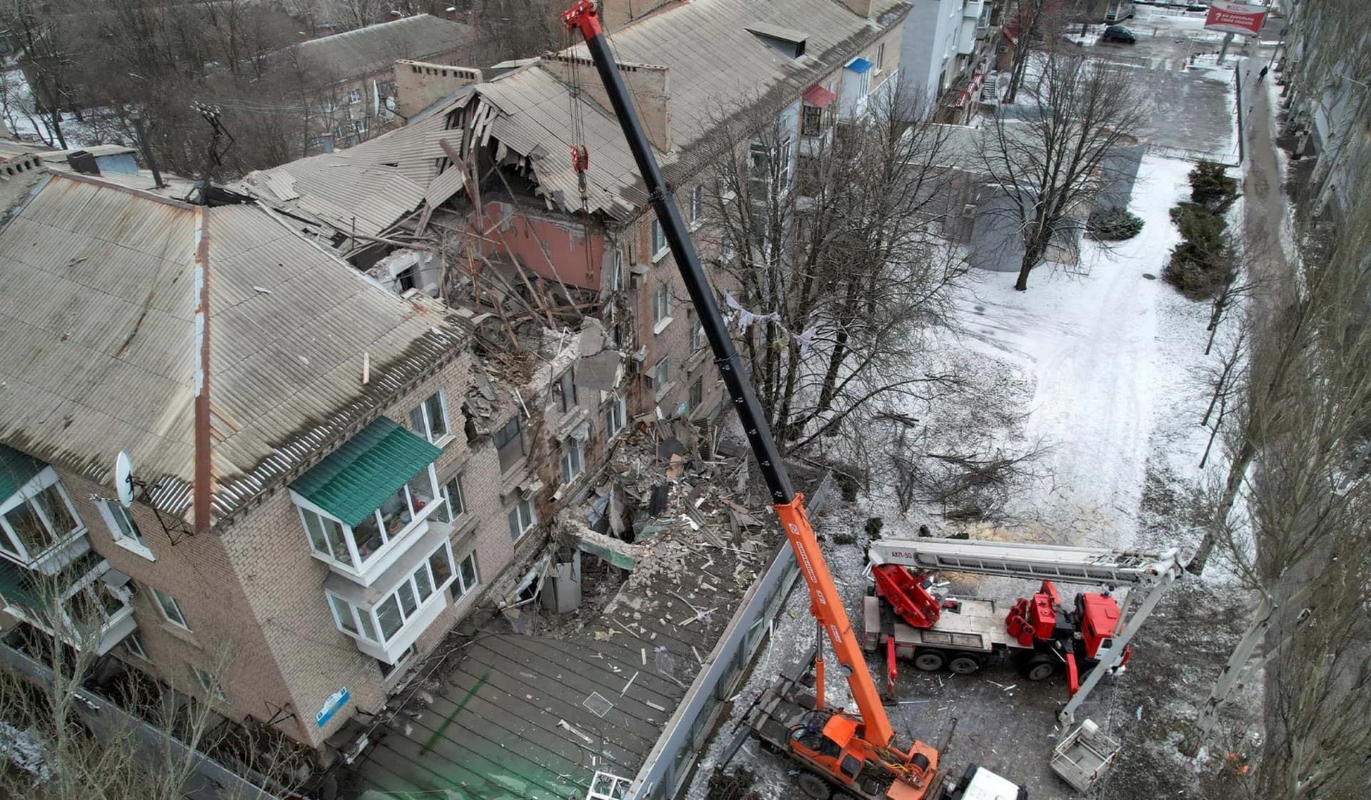 Rescuers use a crane to remove debris of a from a residential building damaged in recent shelling in Donetsk