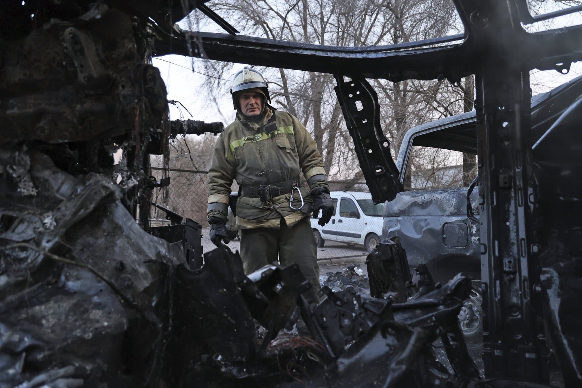 A firefighter examines a burned car in Donetsk