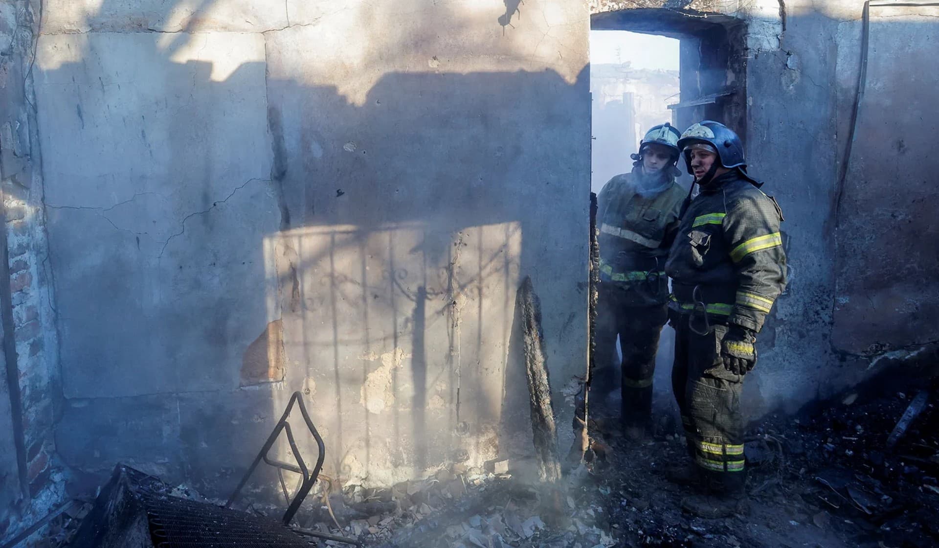 Firefighters work inside a building on the premises of a local church which was damaged in shelling in Donetsk