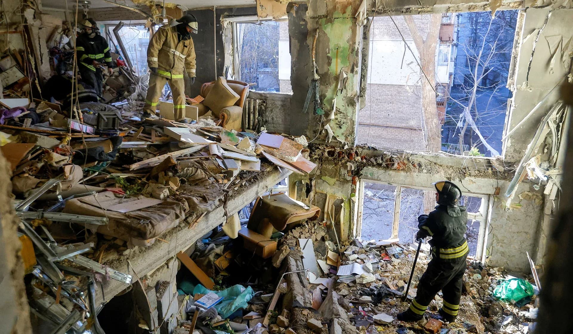 Rescuers remove debris inside destroyed apartments of a residential building hit by shelling in Donetsk