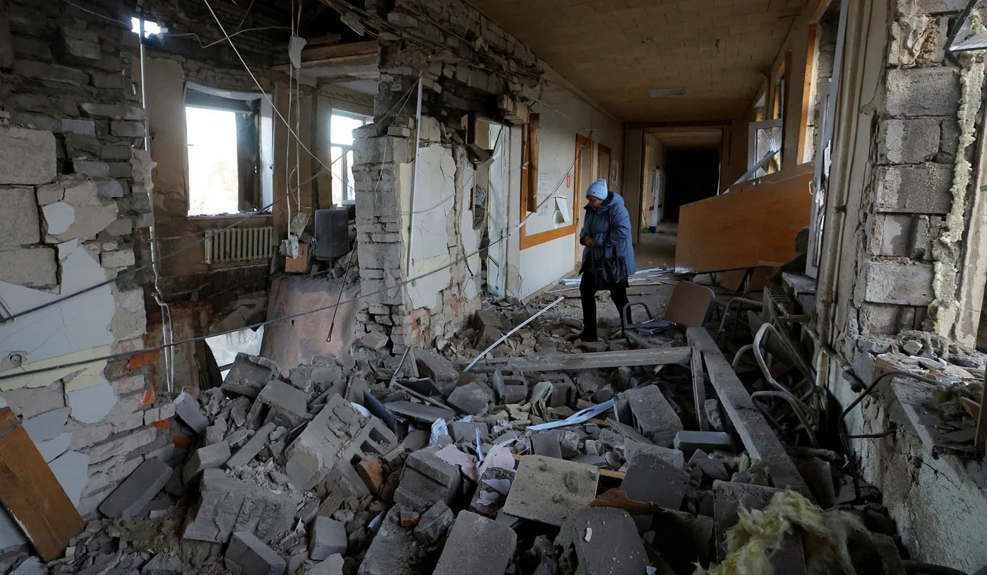 A woman walks inside a hospital damaged by recent shelling in Donetsk