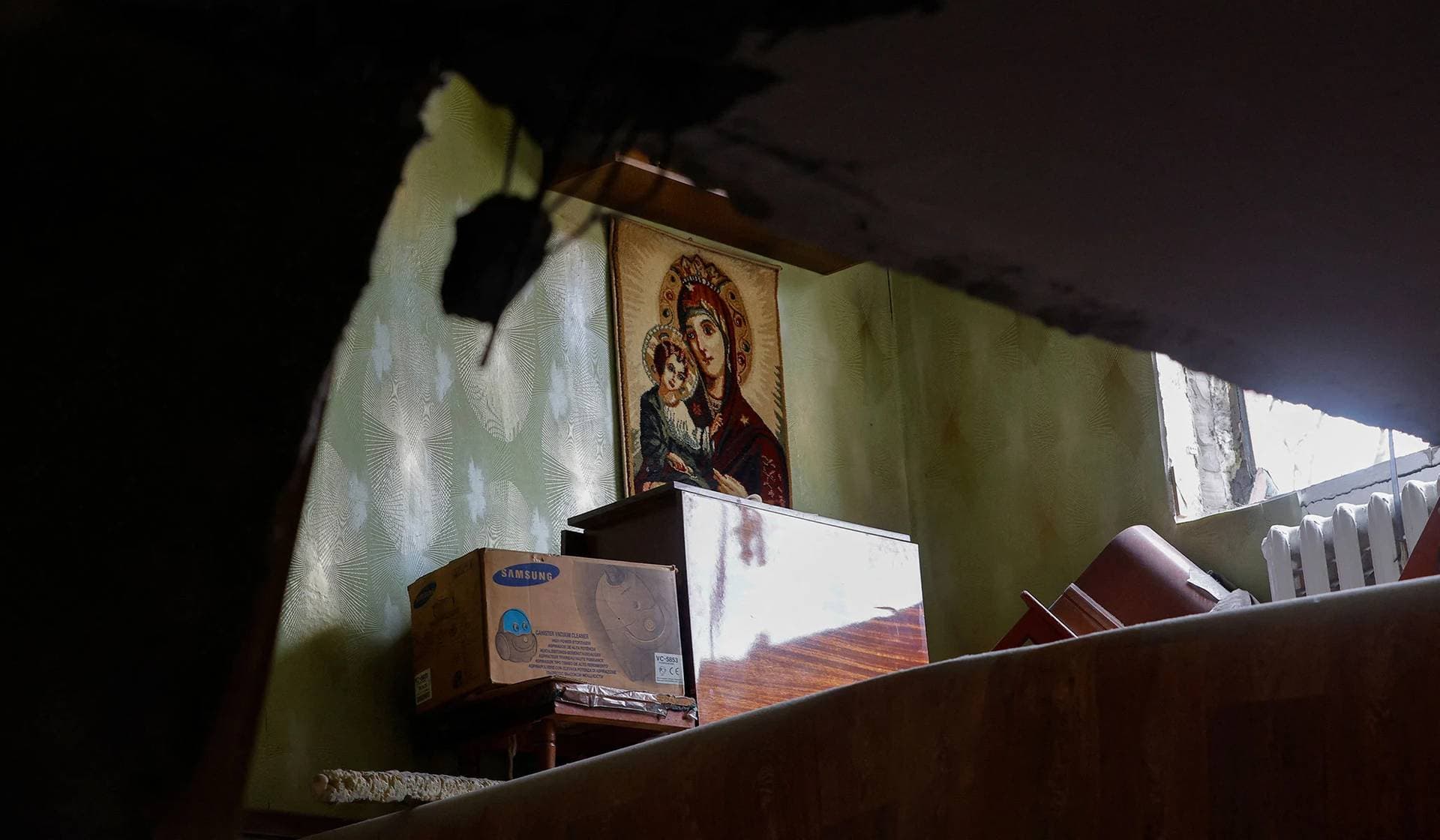 An icon knit inside an apartment of a multi-story apartment block damaged in recent shelling in Donetsk