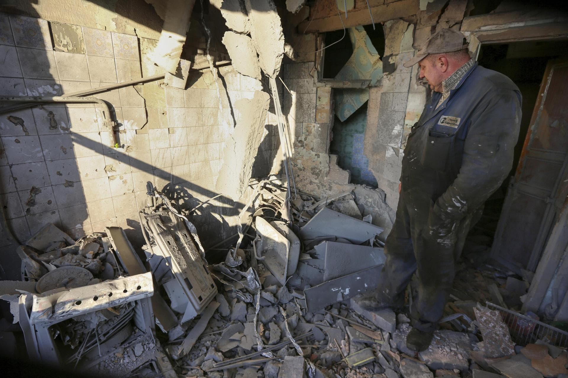 A man examines a damaged apartment building after a shelling in Donetsk
