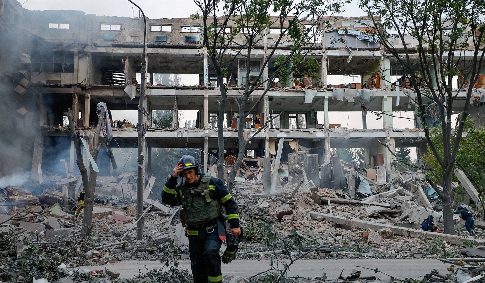A firefighter walks in front of a destroyed building following a Ukrainian strike in Donetsk