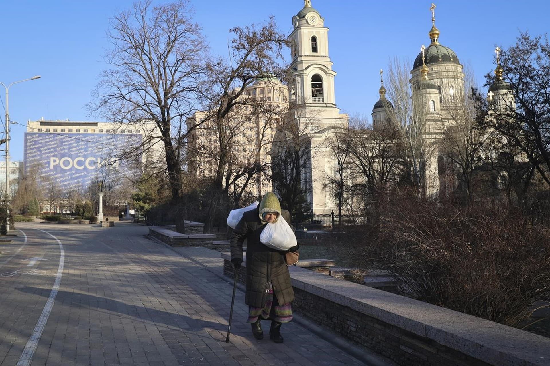 An elderly woman walks down a street central Donetsk