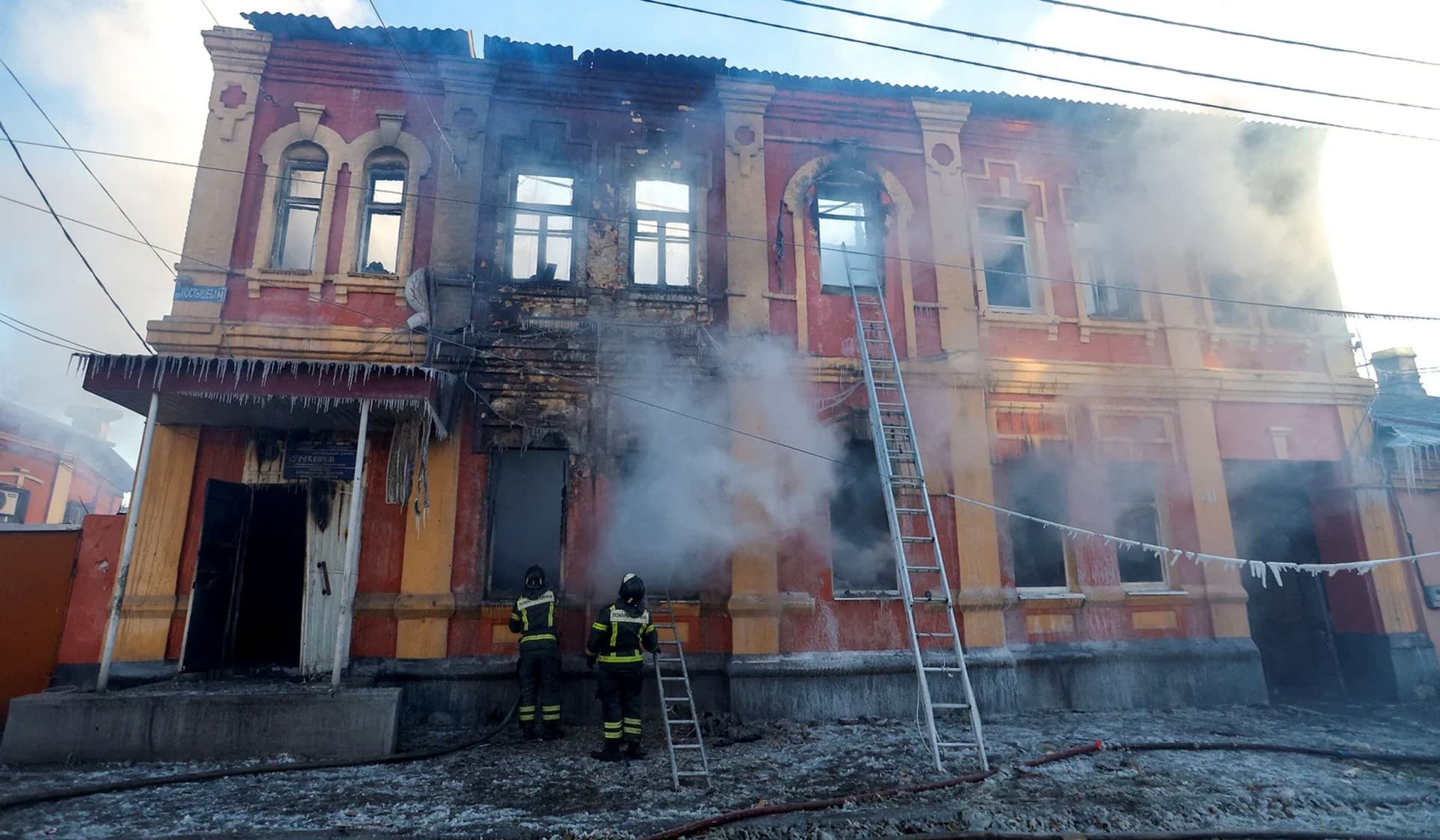 Firefighters work outside an office building destroyed in shelling in Donetsk
