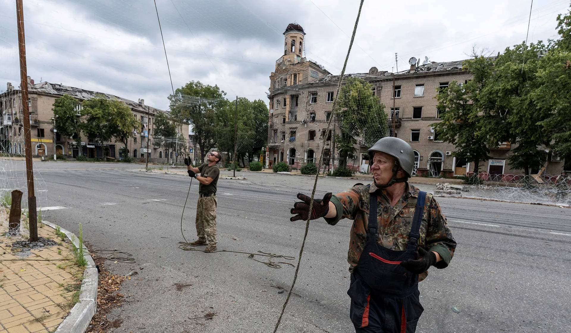 Servicemen of the Ukrainian Armed Forces repair anti-drone nets in the frontline town of Druzhkivka