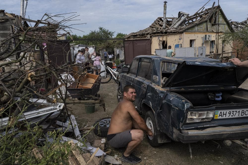 Residents recover belongings from their damaged houses after a missile strike in Druzhkivka