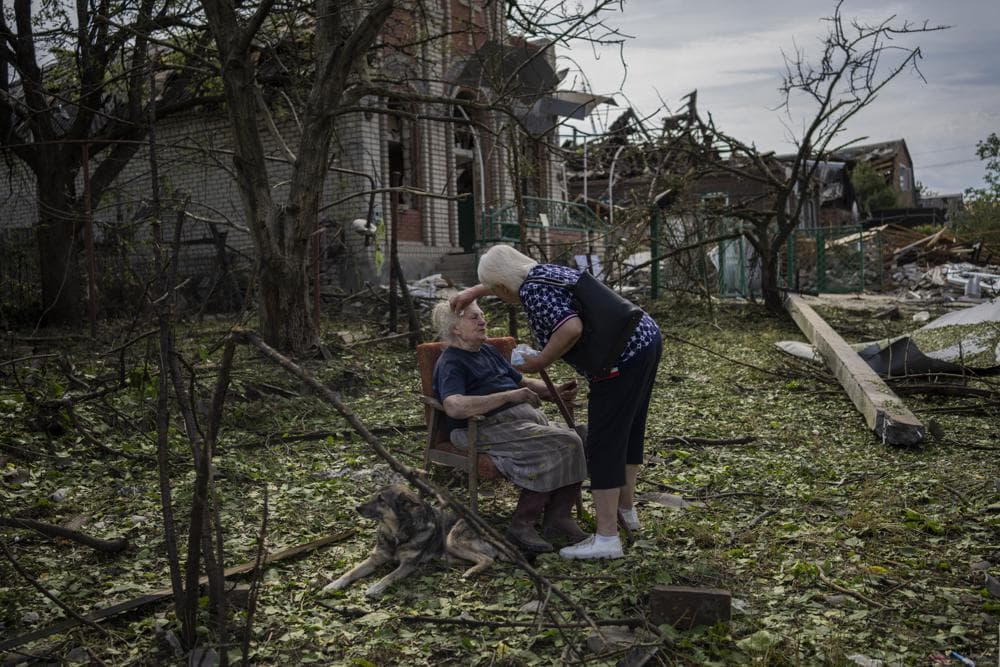 Elena Holovko sits among debris outside her house damaged after a missile strike in Druzhkivka