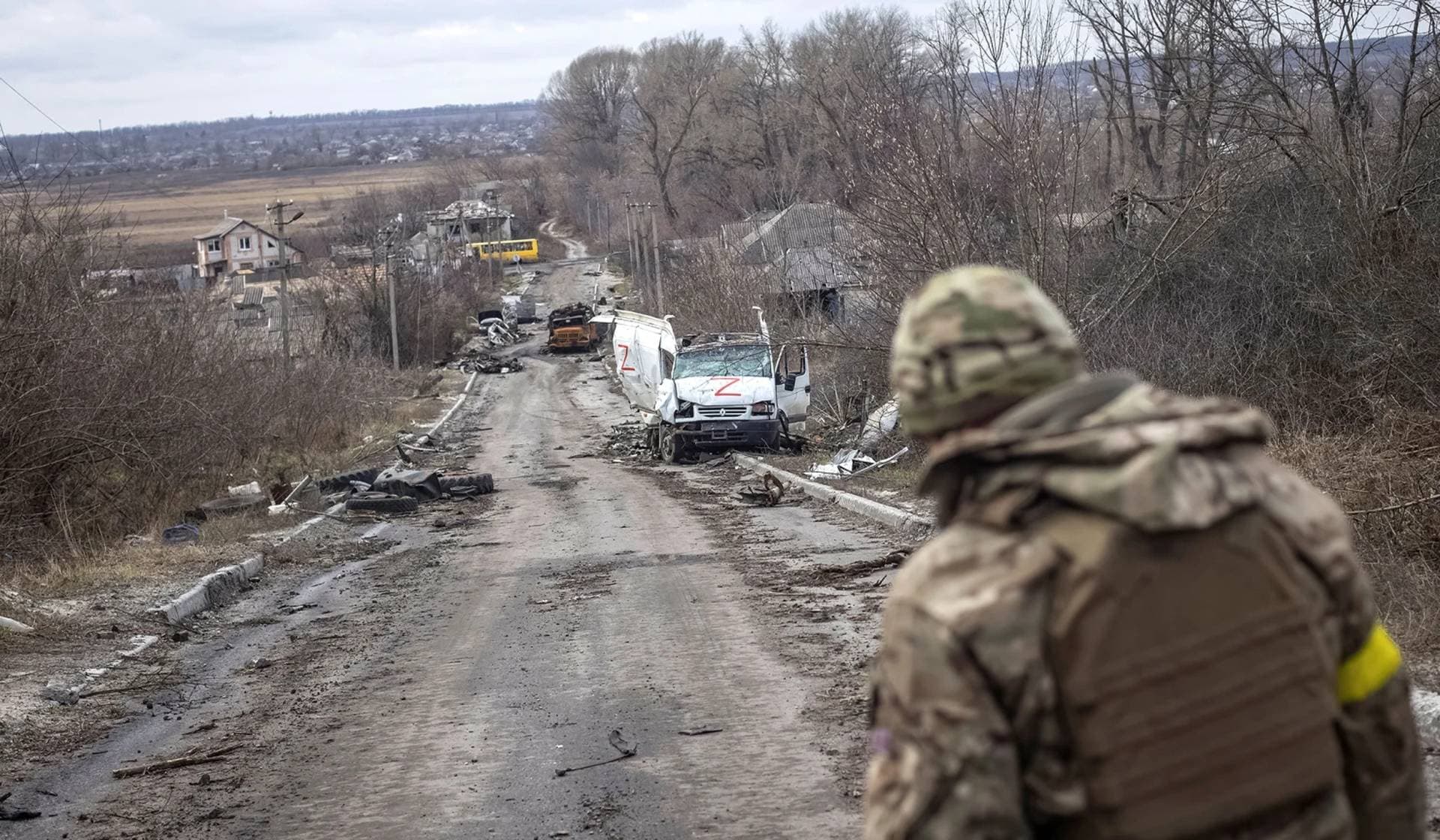 A Ukrainian serviceman looks at an empty street in the village of Torske