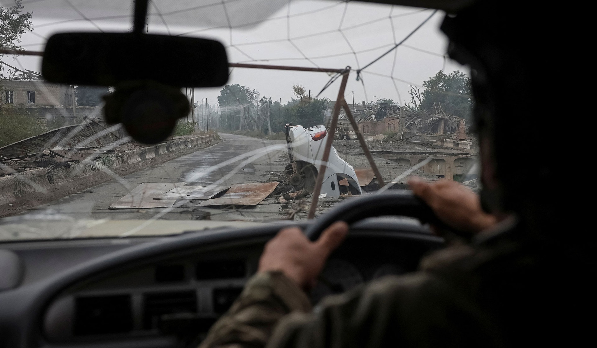 A Ukrainian serviceman drives a vehicle in the frontline town of Druzhkivka
