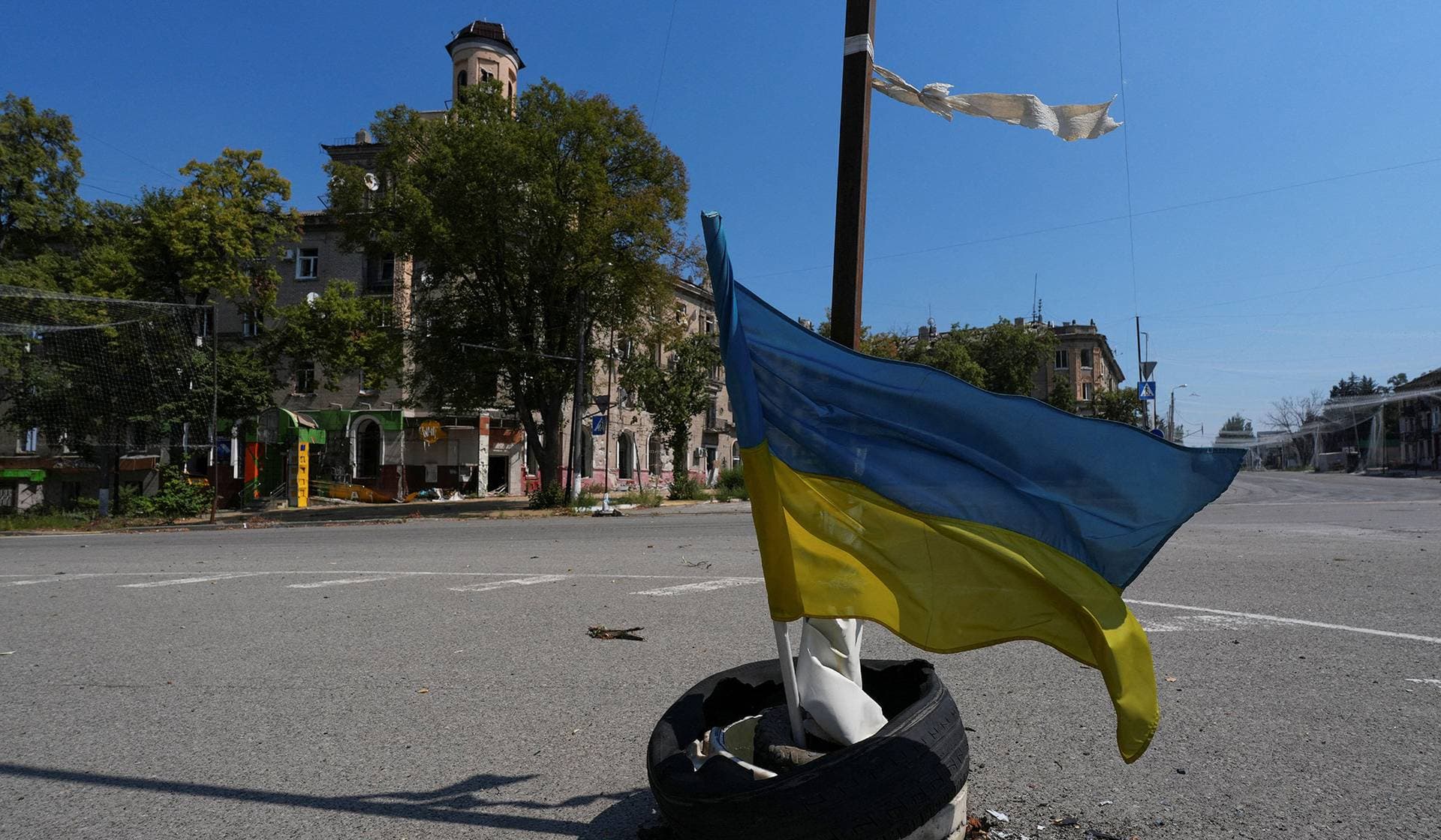 A Ukrainian national flag waves on a street in the center of the frontline town of Druzhkivka