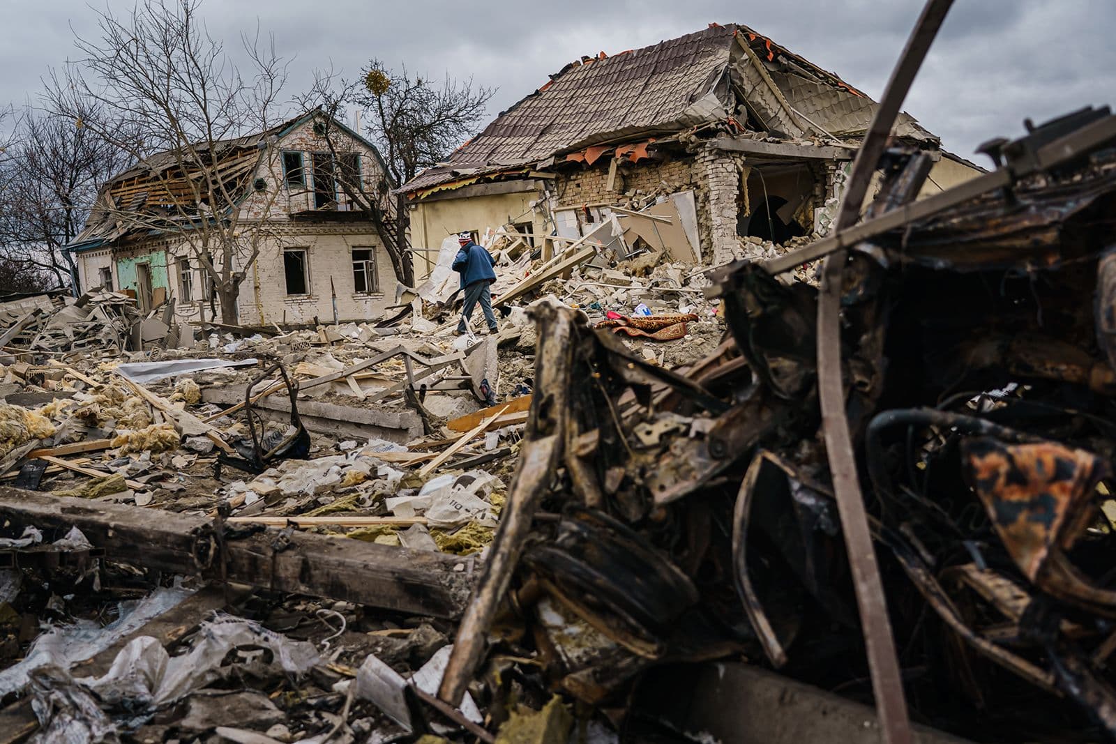 Local residents help clear the rubble of a home that was destroyed by a suspected Russian airstrike in Markhalivka