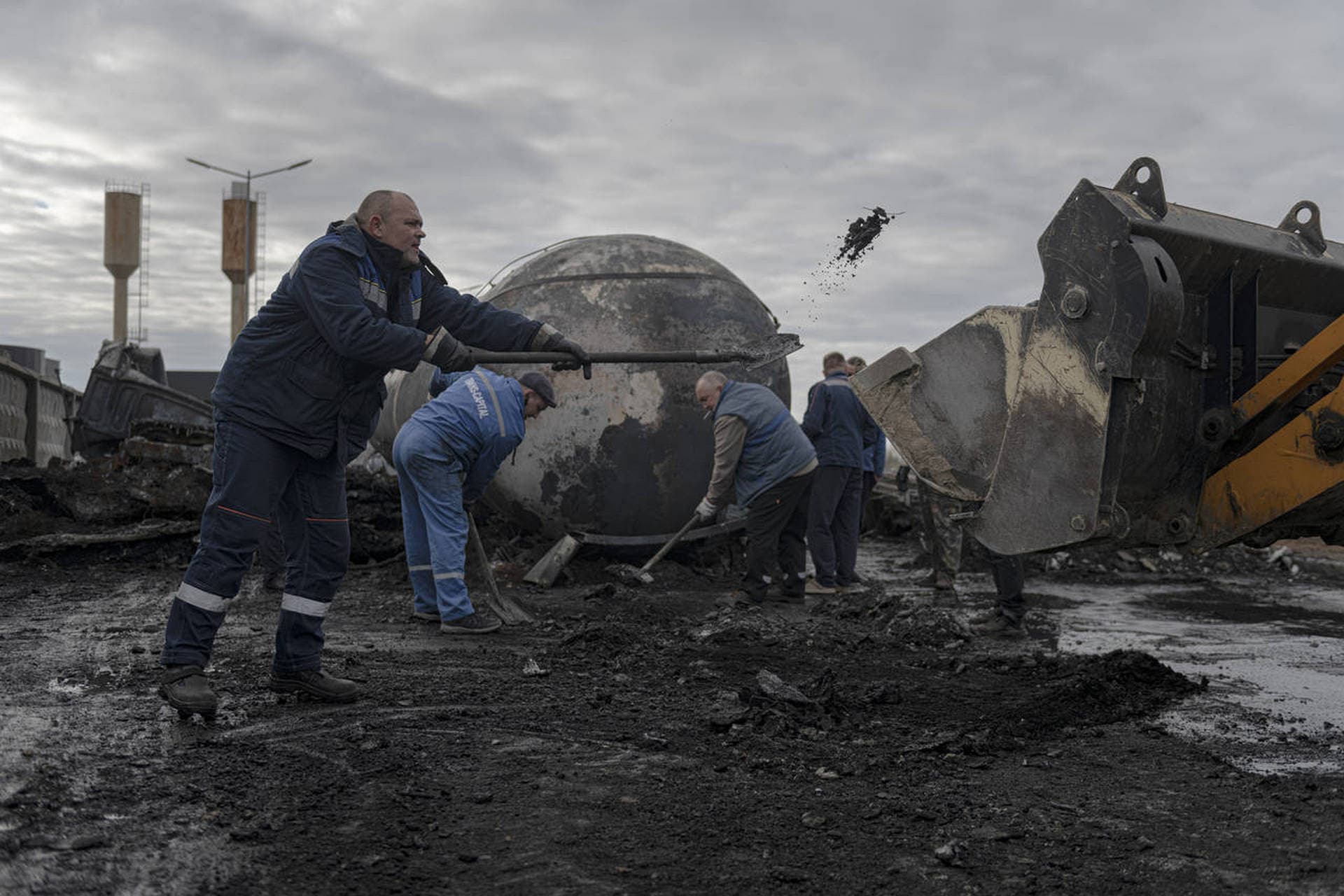 Workers clean up at a fuel depot hit by Russian missile in the town of Kalynivka