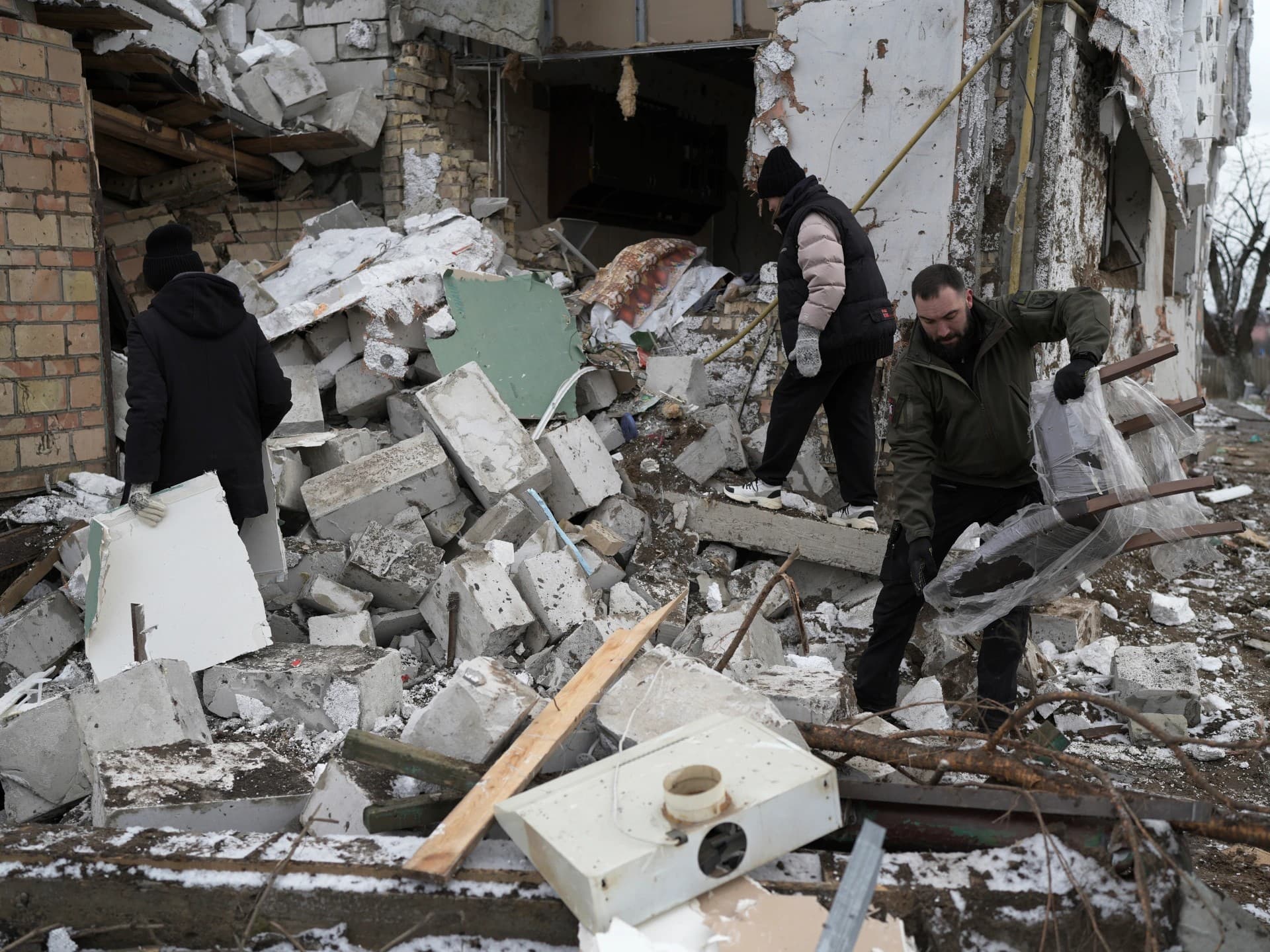 People check a destroyed house after a Russian rocket attack in Hlevakha