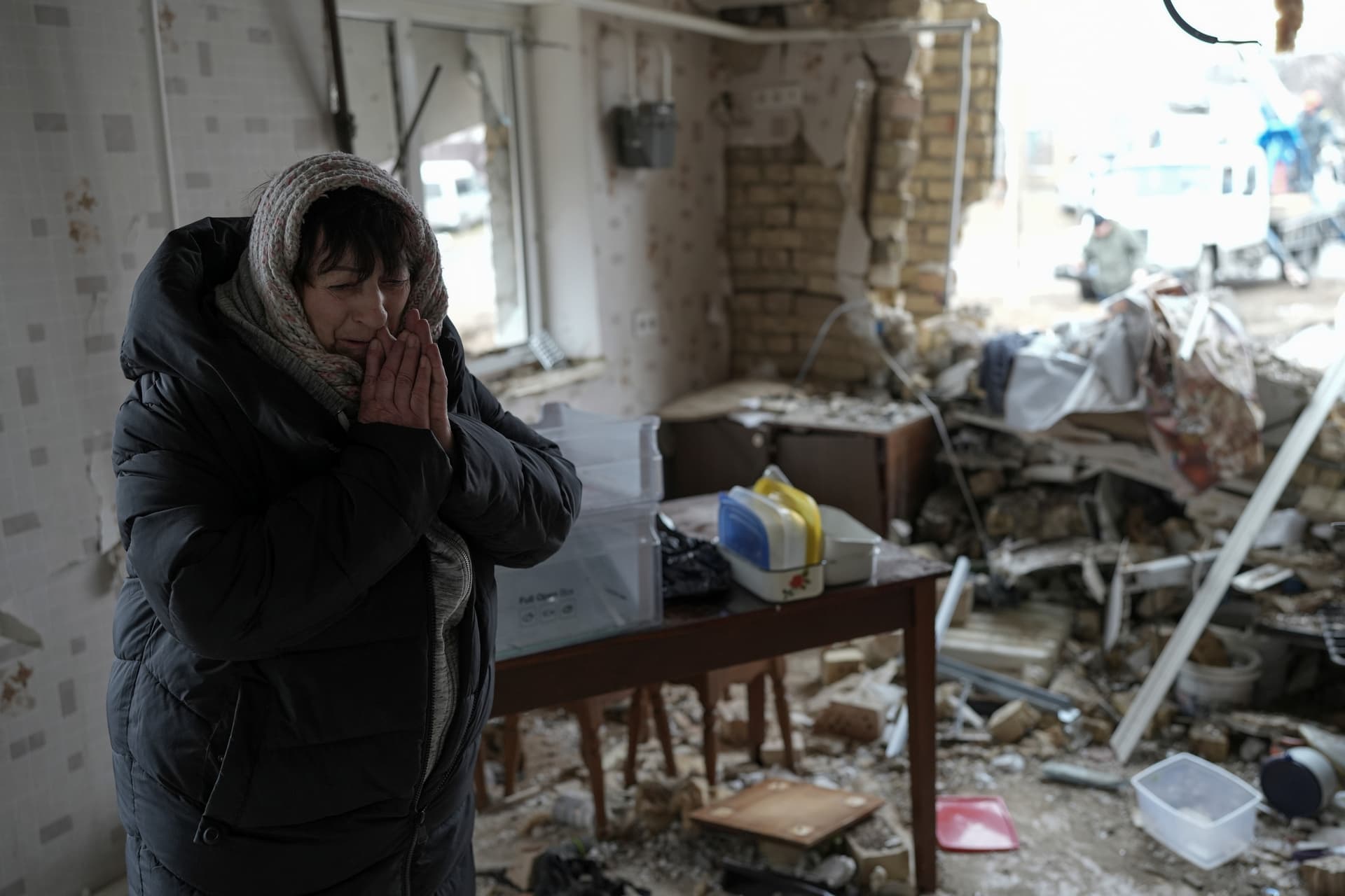 Halina Panasian, 69, reacts inside her destroyed house after a Russian rocket attack in Hlevakha