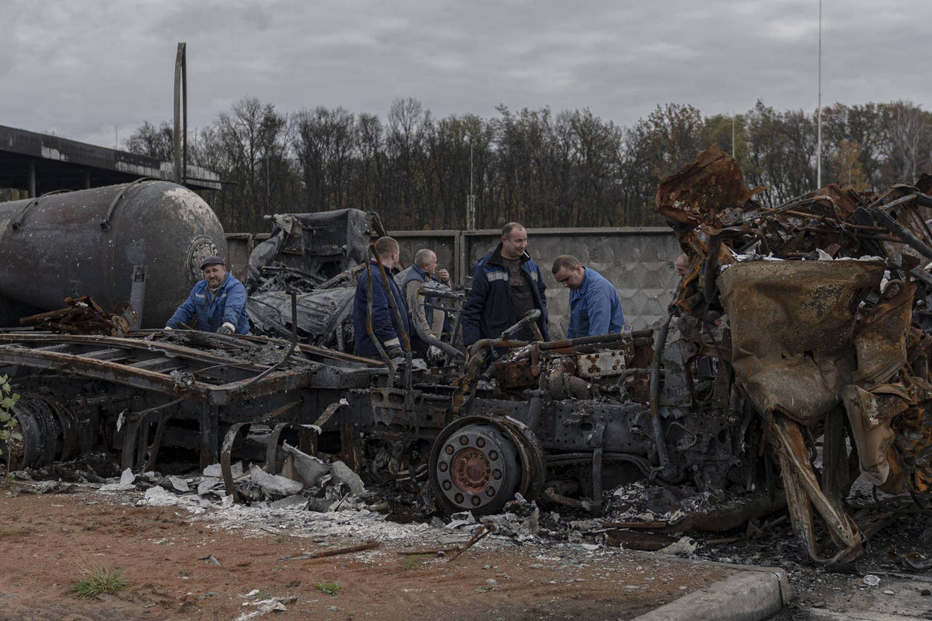 Workers inspect a fuel depot hit by Russian missile in the town of Kalynivka