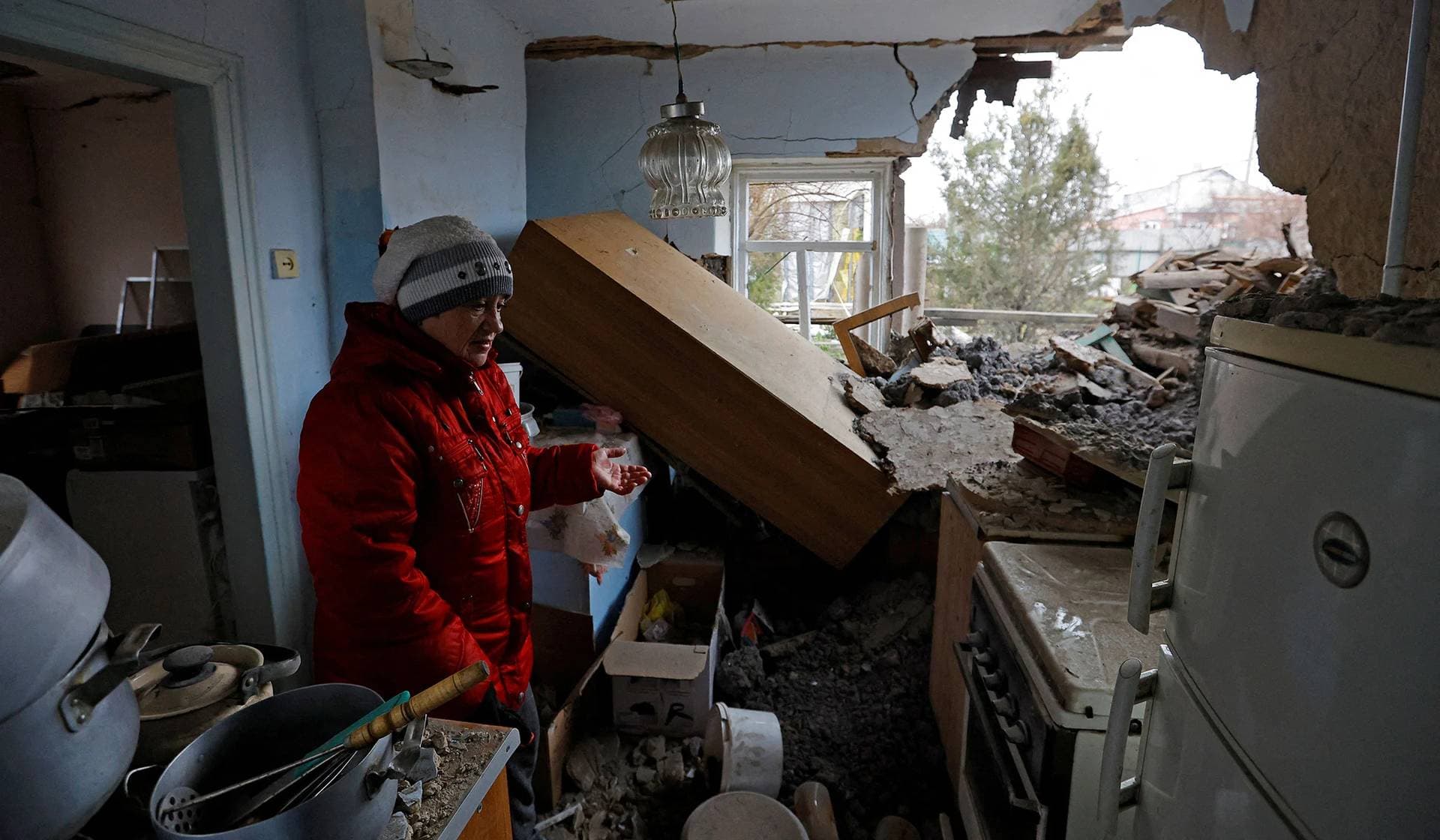 Local resident stands inside her house which was heavily damaged in recent shelling in Horlivka