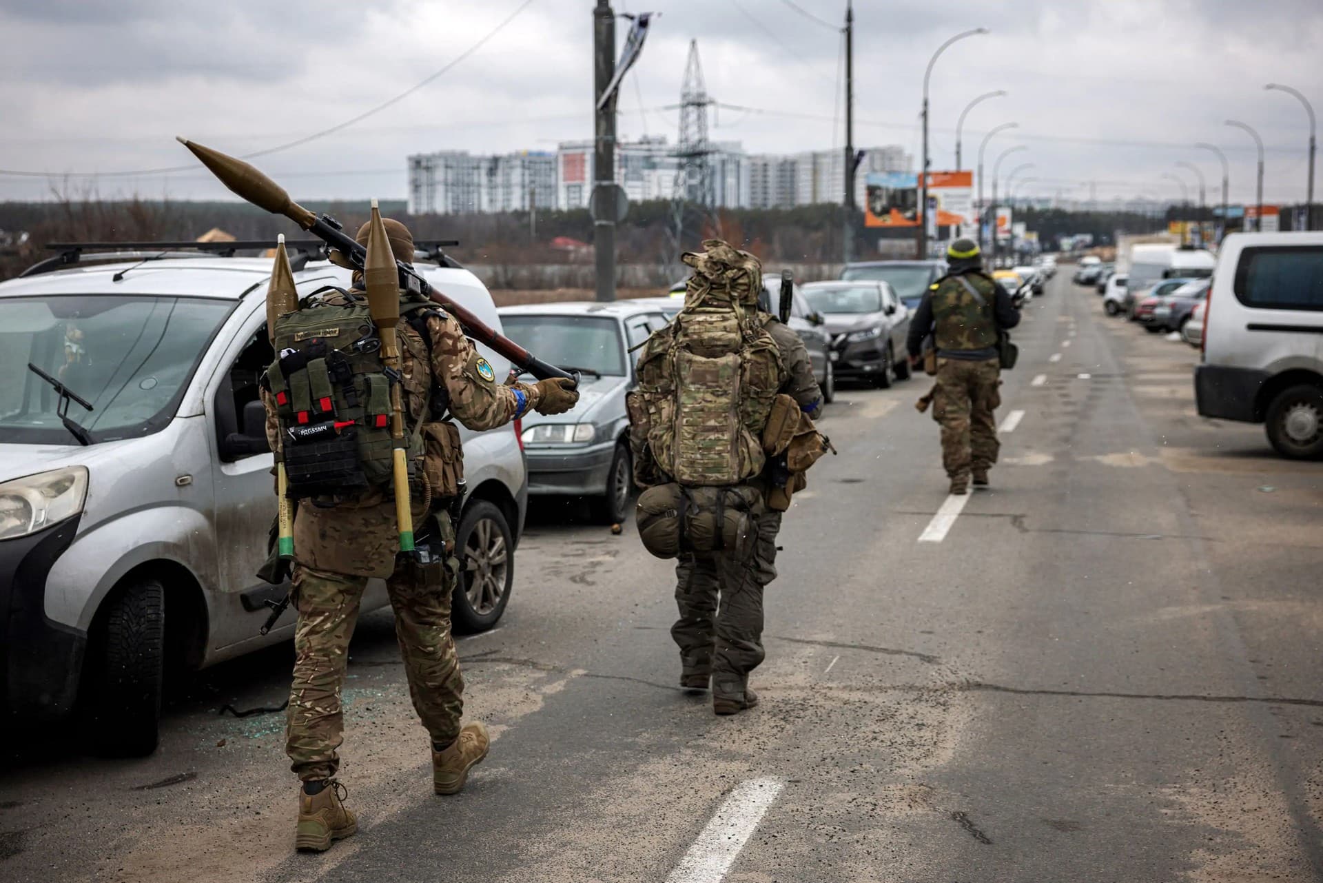 Ukrainian servicemen carry rocket-propelled grenades and sniper rifles near of Irpin