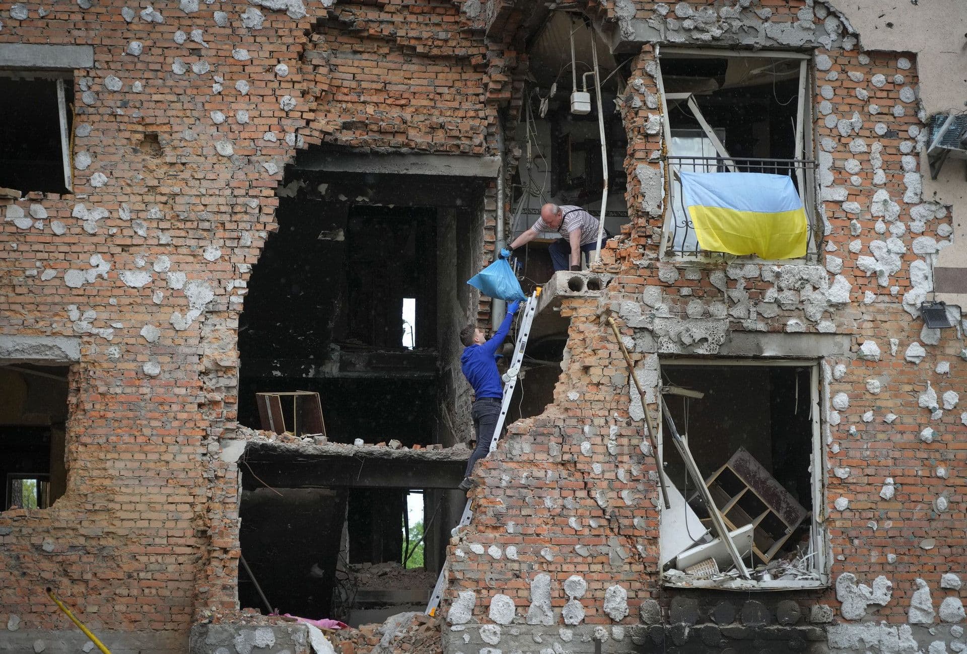 Residents take out their belongings from their house ruined by the Russian shelling in Irpin