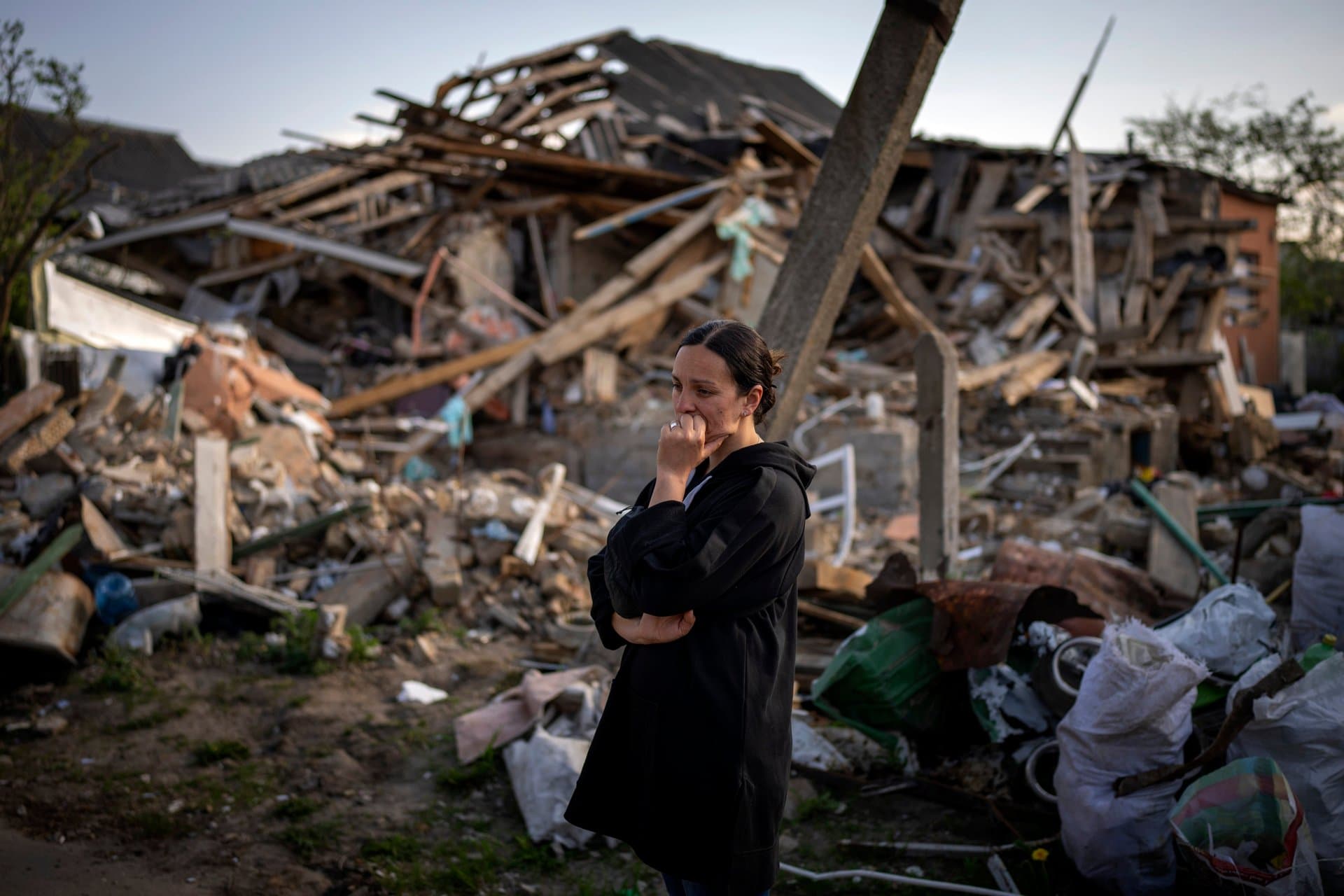 Anna Shevchenko reacts next to her home in Irpin completely destroyed by bombing