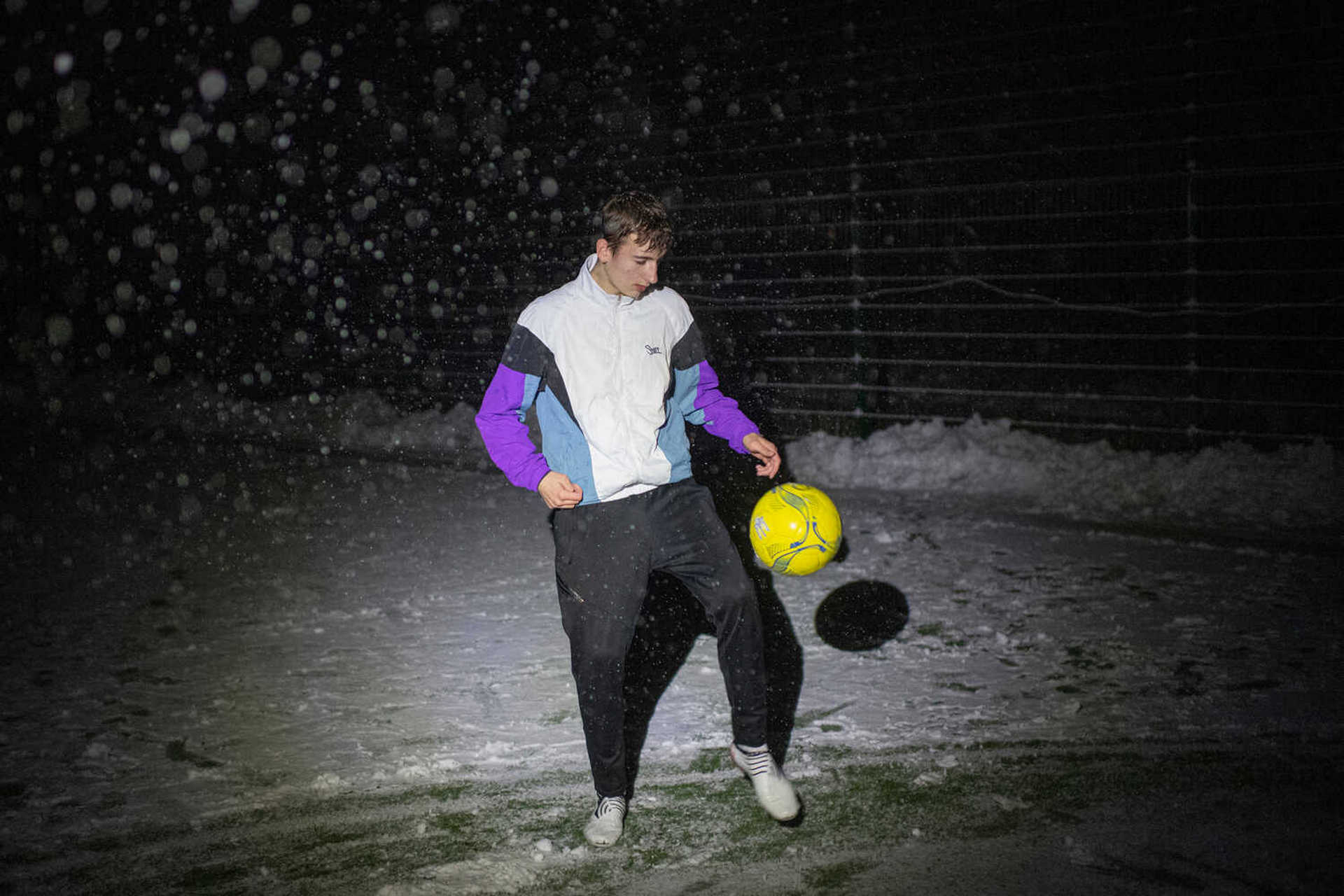Student Ivan Mahyrovskyi, 16, controls the ball in a soccer game during a blackout in Irpin