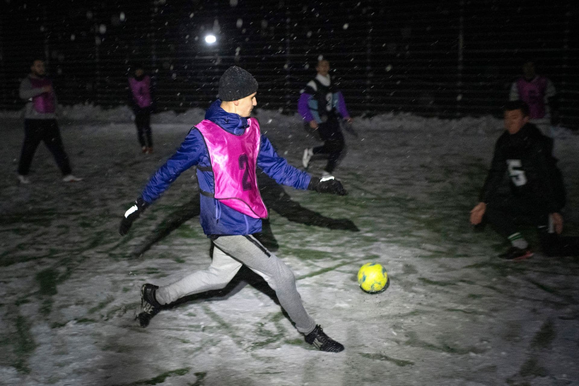 Men take part in a soccer game during a blackout in Irpin