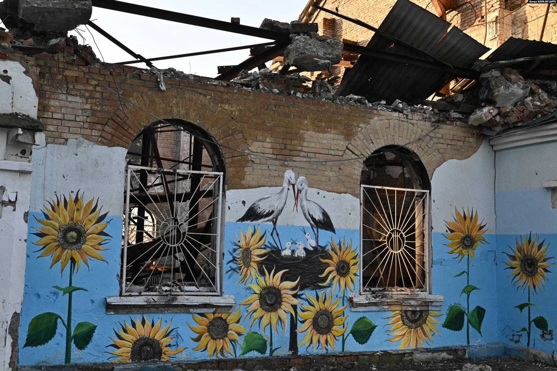 Sunflowers, a beloved symbol of Ukraine, and a family of storks adorn the shattered walls of Irpin's Central House of Culture