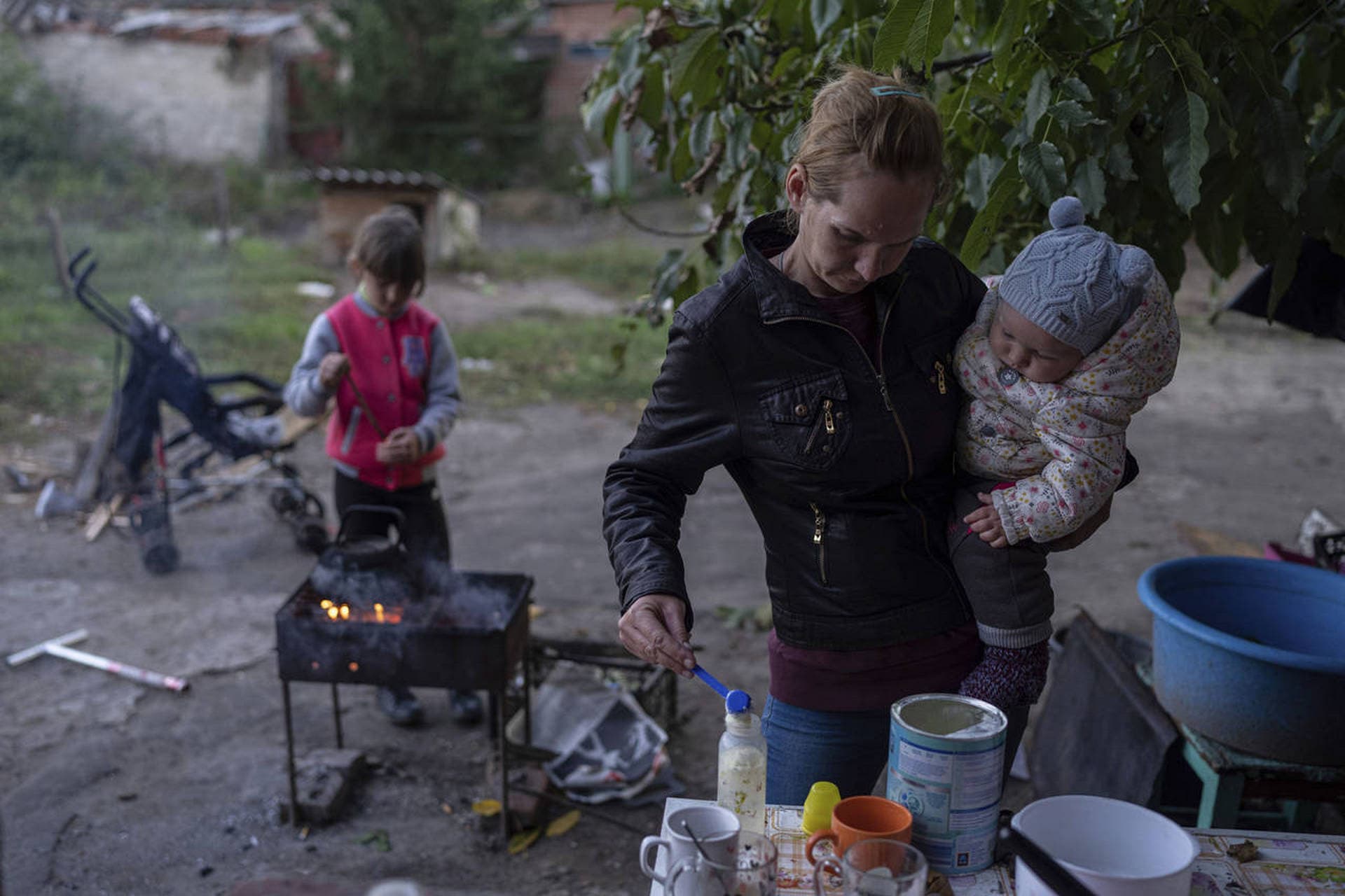 Margaryta Tkachenko prepares food on the open fire for her 9-month-old daughter Sophia in the recently retaken town of Izium