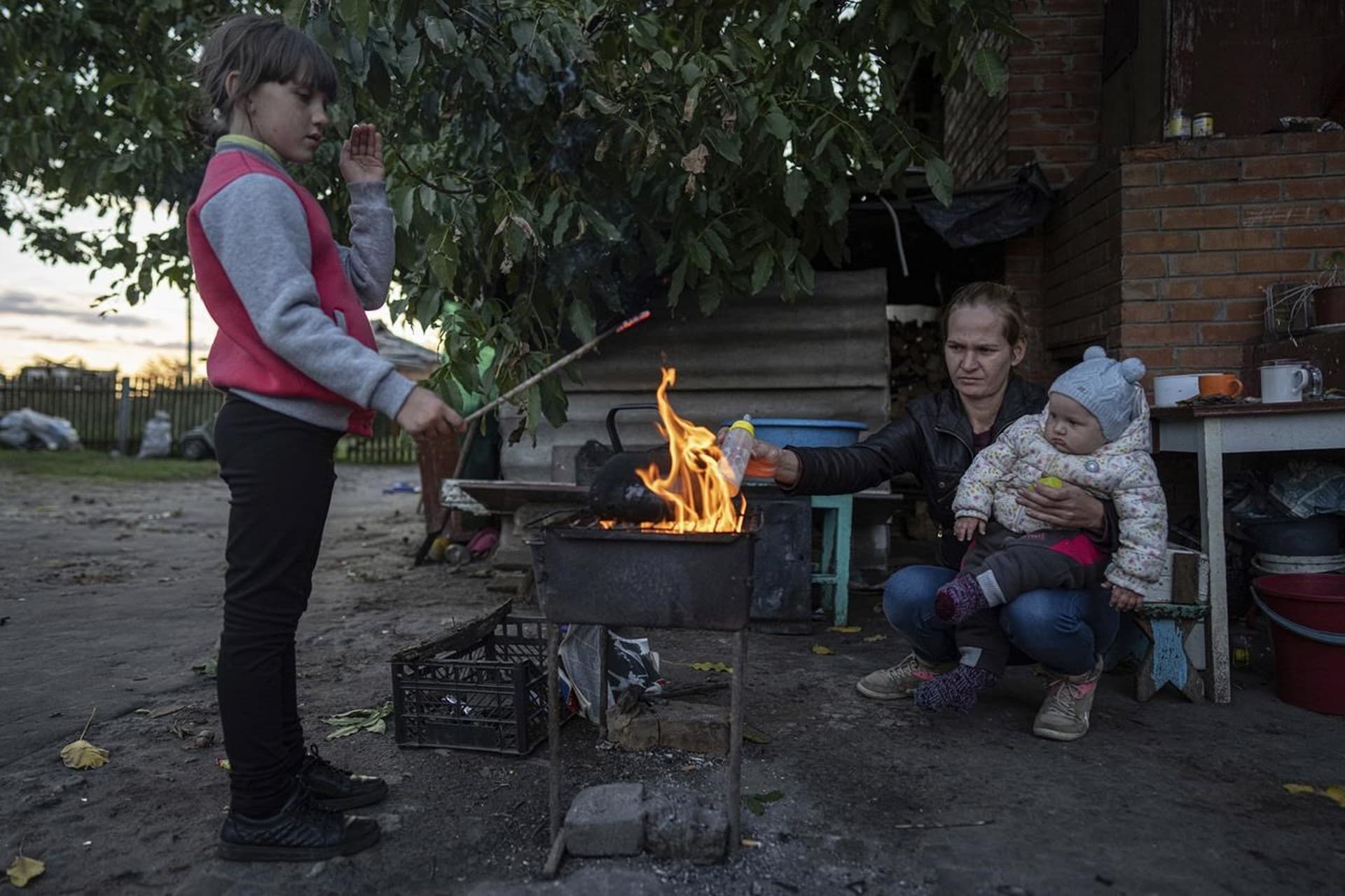 Margaryta Tkachenko warms food on an open fire for her 9-month-old daughter Sophia in the recently retaken town of Izium