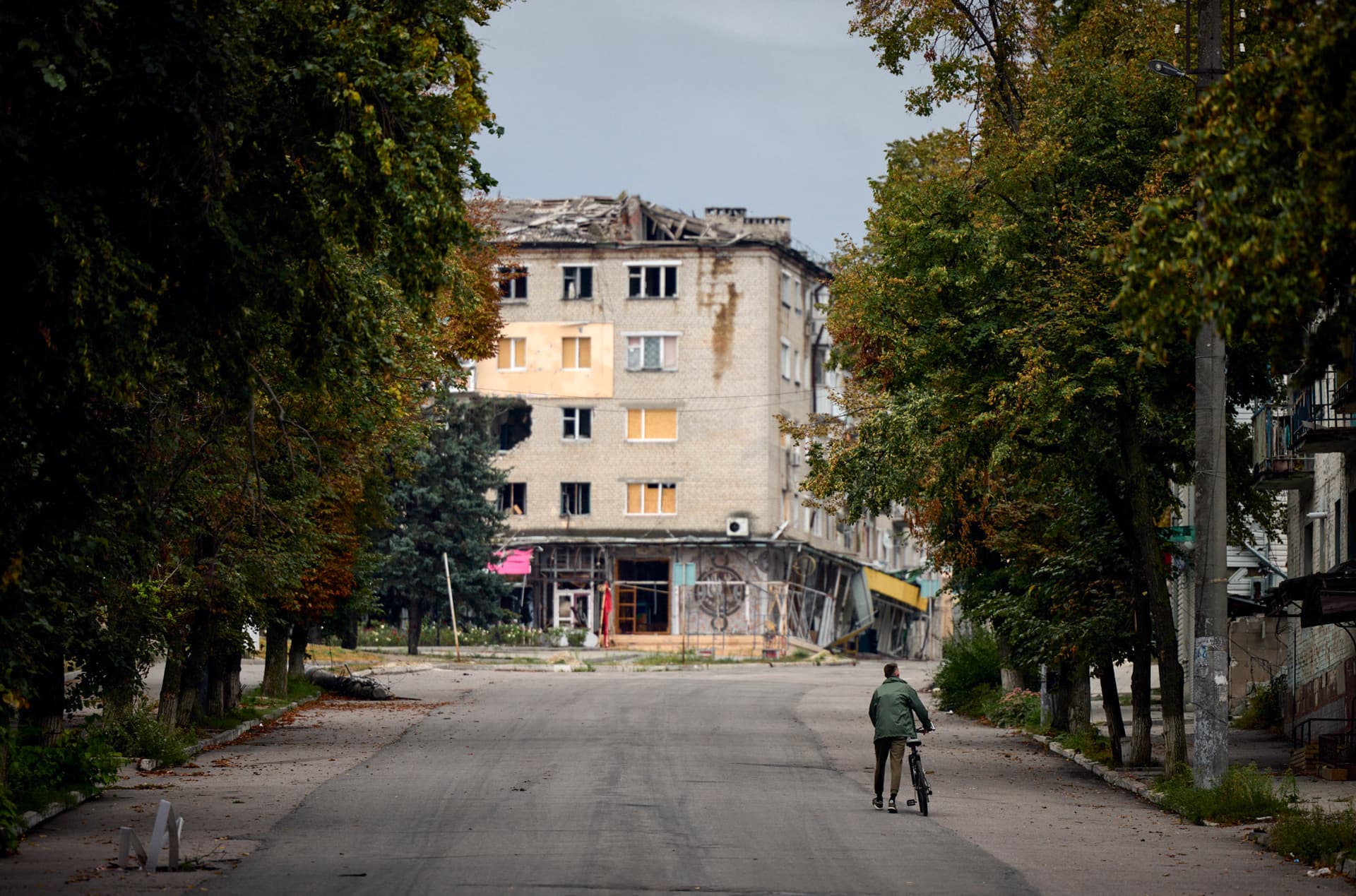 A man takes his bike in a deserted street in the centre of the freed town of Izium