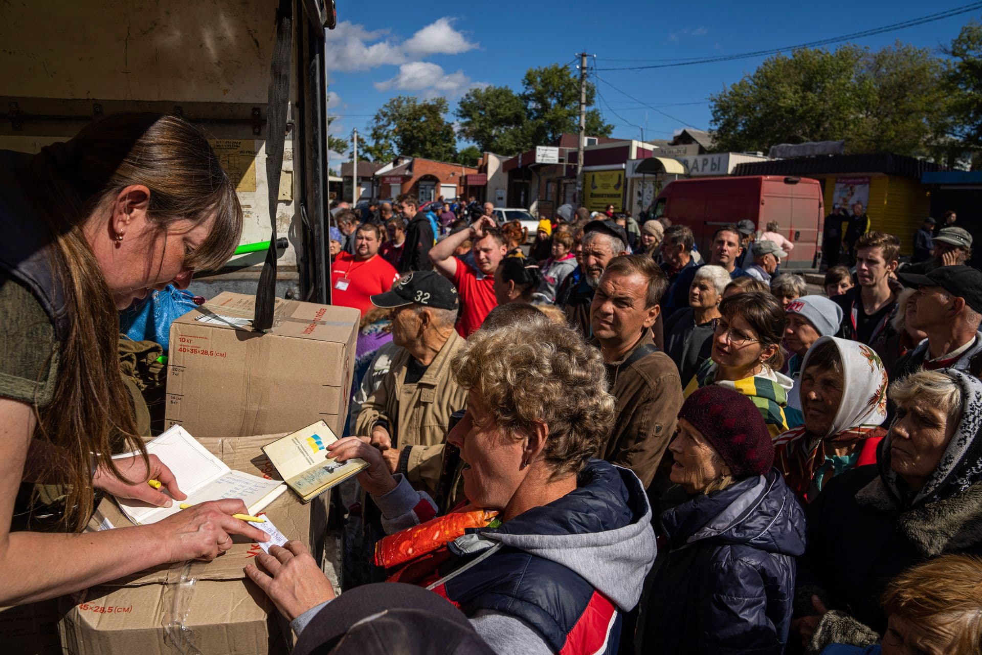 People receive packages from their relatives in the recently retaken area of Izium